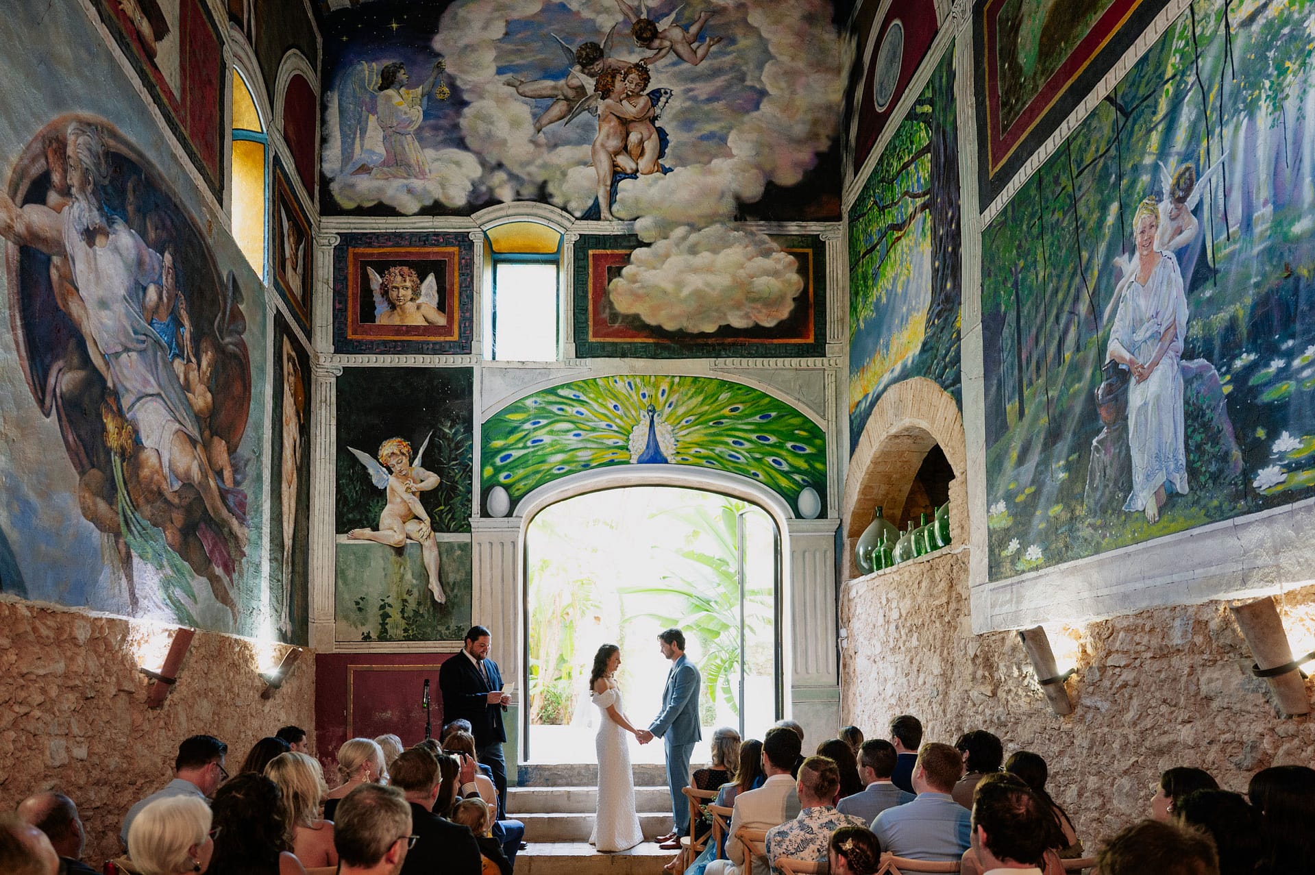 Couple exchanges vows at an indoor wedding with vibrant murals - Barcelona Wedding Photographer