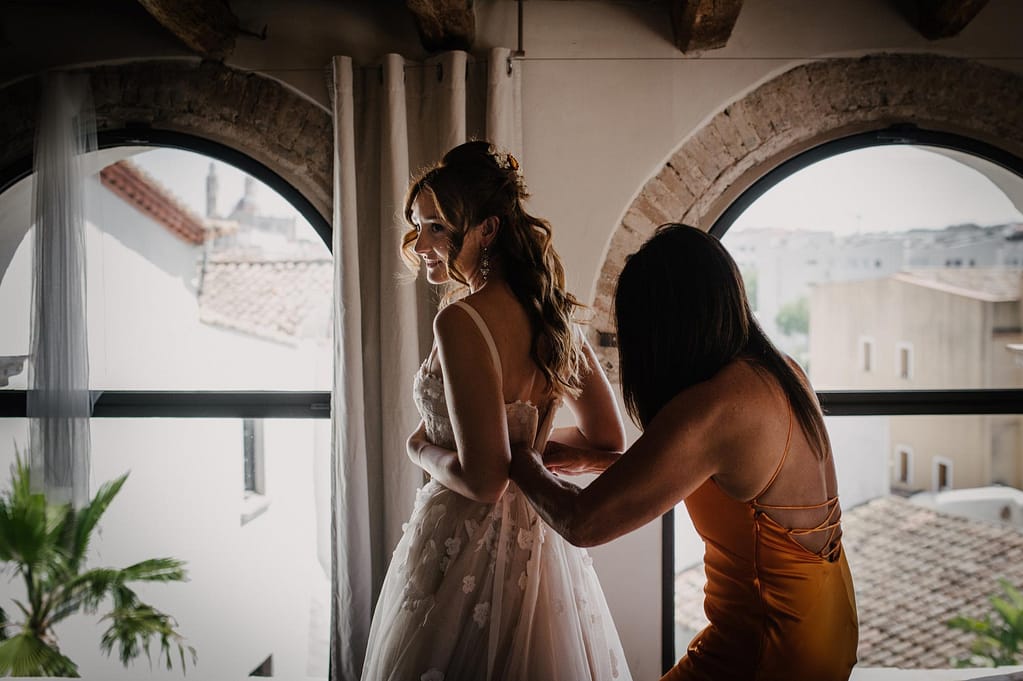 Bride Safia getting ready with help from a mother in an orange dress - Sitges Wedding Photographer