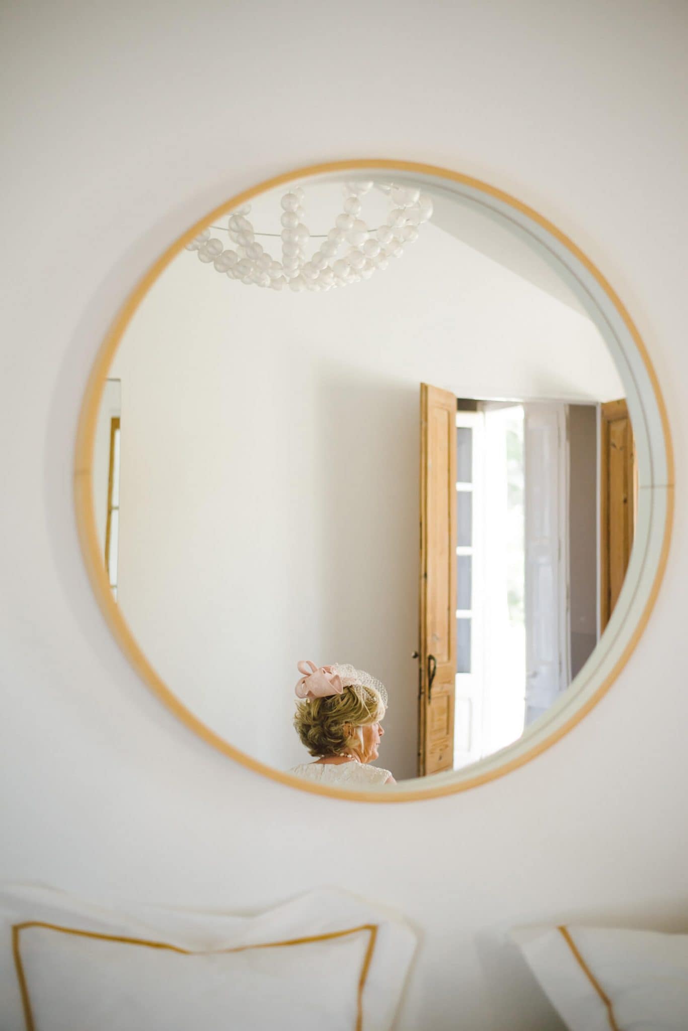 Bride in a pink fascinator reflected in a mirror at Casanova Estate wedding venue. - Barcelona Wedding Photographer