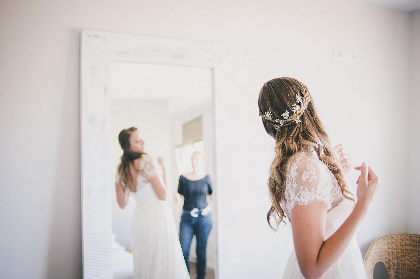 Bride in lace dress with floral headpiece, reflected in mirror with bridesmaids, wedding photographer Barcelona - Barcelona Wedding Photographer