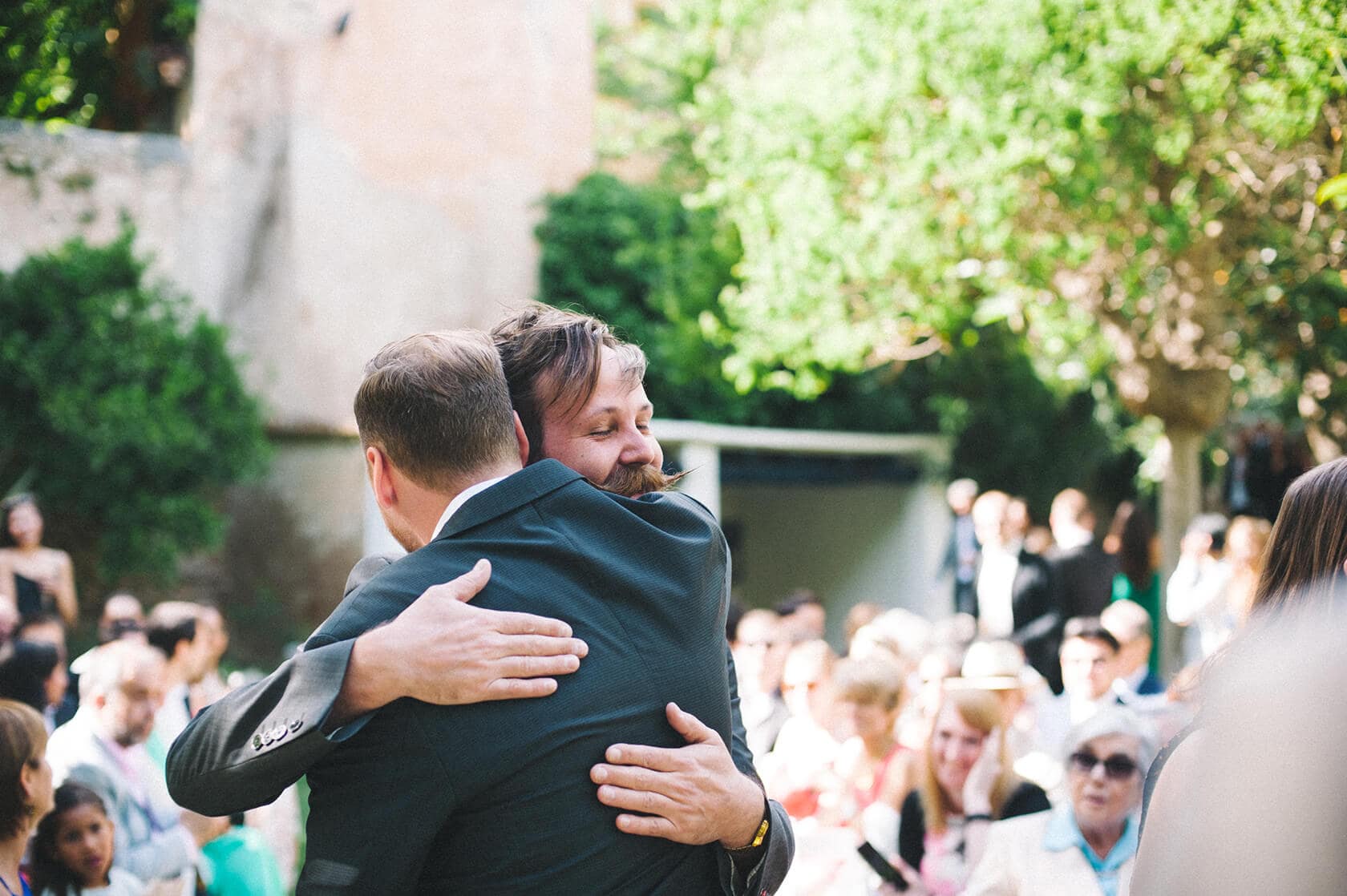 Groom hugs guest at destination wedding villa Almanita, Sitges - Barcelona Wedding Photographer