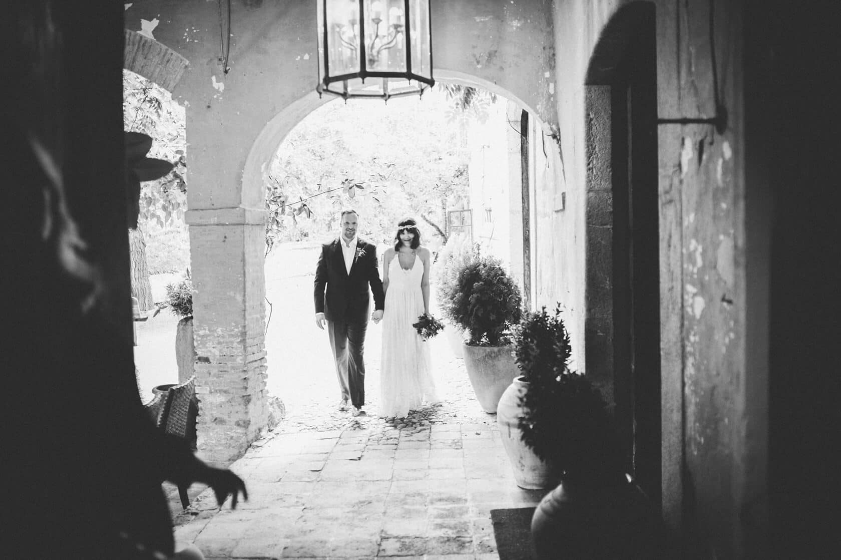 Bride and groom walking through archway at Villa Almanita destination wedding in Sitges - Barcelona Wedding Photographer