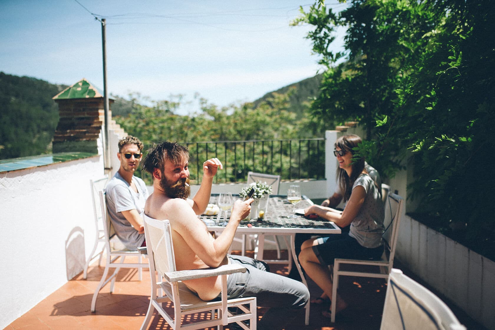Clara & Toph's wedding villa guests enjoy drinks at a table in Sitges - Barcelona Wedding Photographer