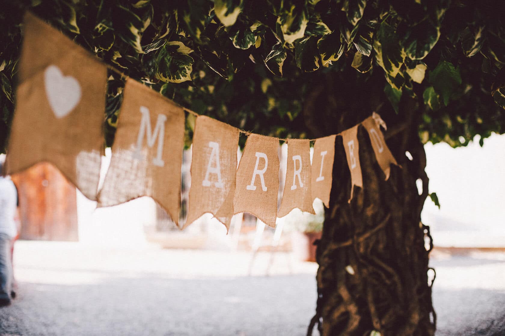 Burlap banner with "MARRIED" and a heart, hanging from a tree at a wedding in Barcelona. - Barcelona Wedding Photographer