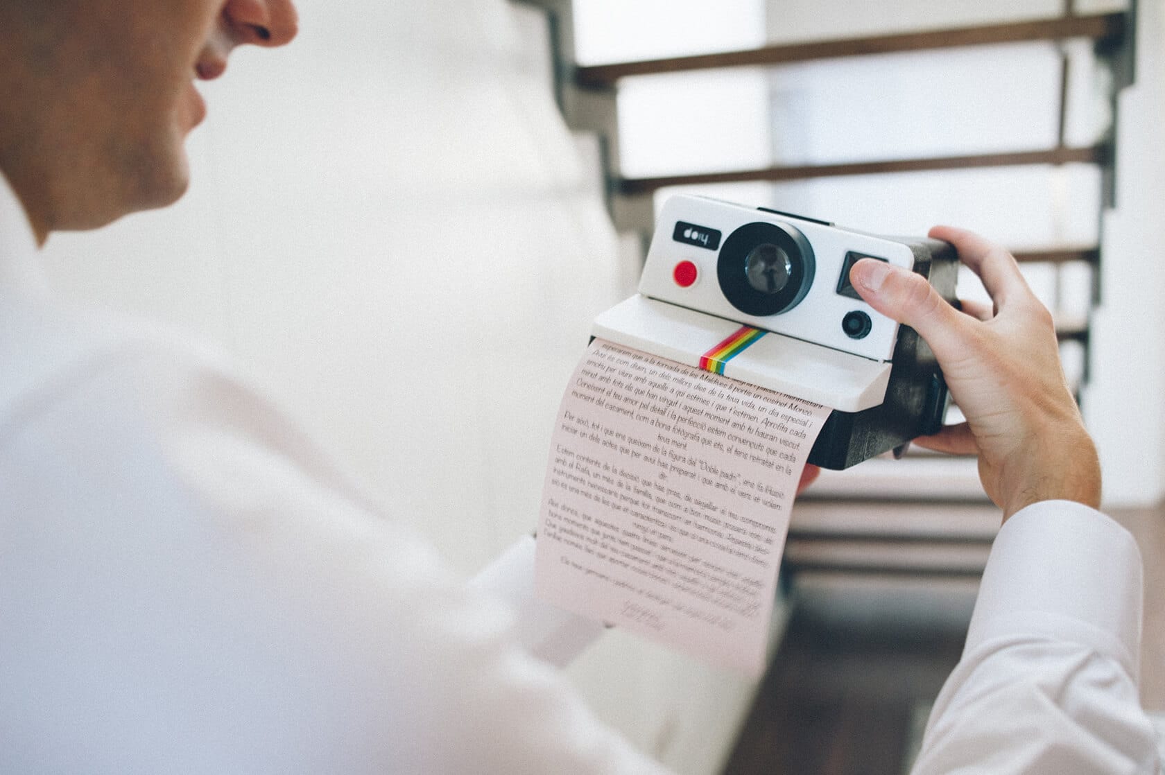 Groom reads a Polaroid photo at a Barcelona wedding - Barcelona Wedding Photographer