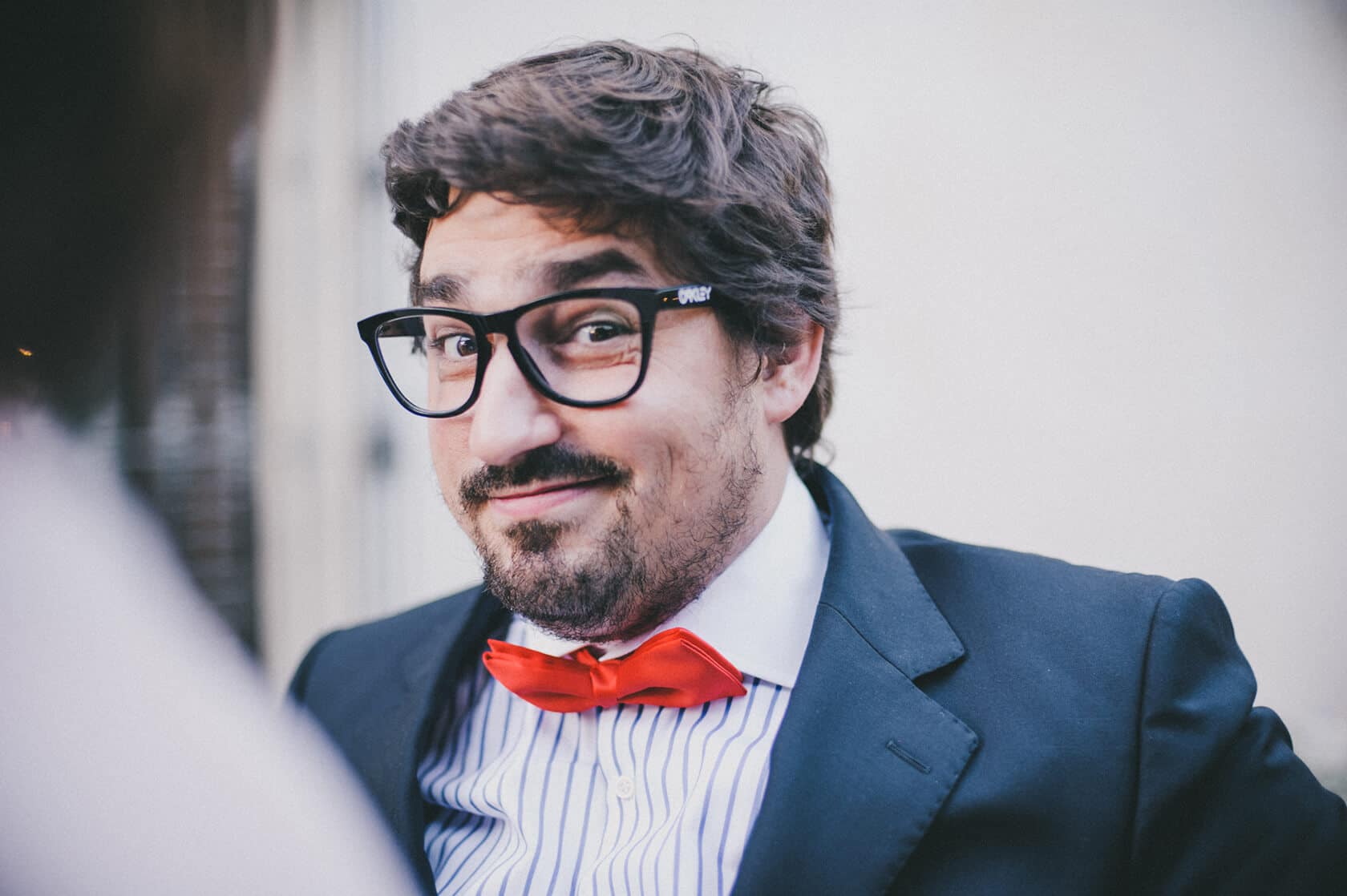 Groom in black suit and red bow tie smiles for wedding photographer in Barcelona - Barcelona Wedding Photographer