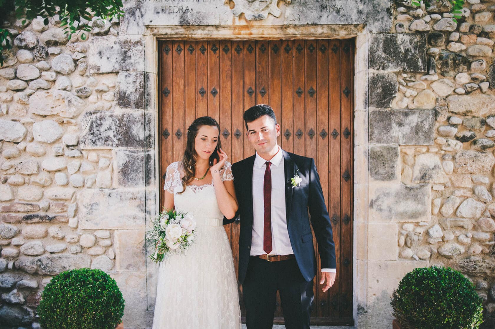 Bride and groom Cris & Rafa outside a rustic wooden door, wedding photographer Barcelona - Barcelona Wedding Photographer