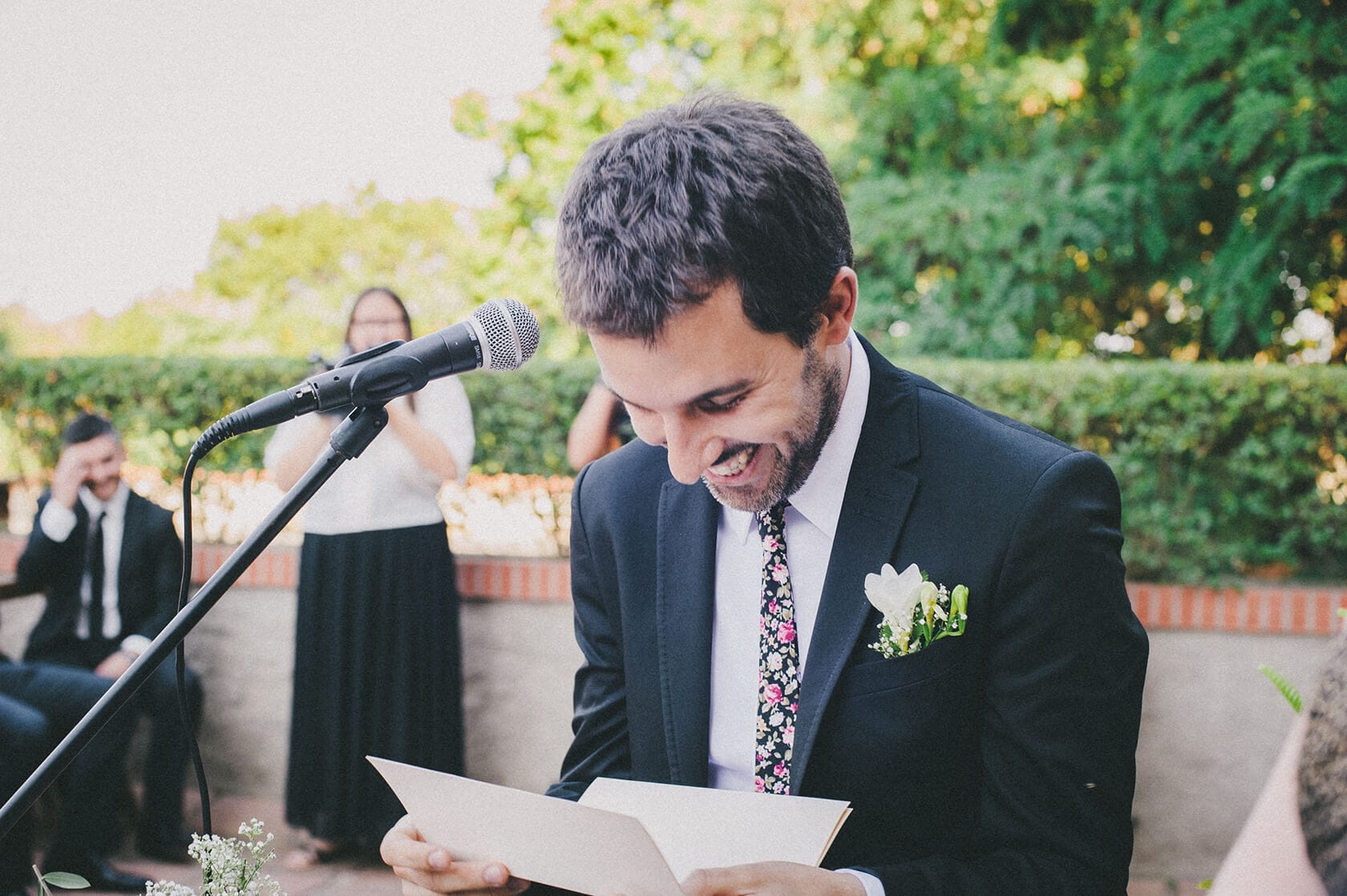 Groom reads vows at a Barcelona wedding, smiling at the camera. - Barcelona Wedding Photographer
