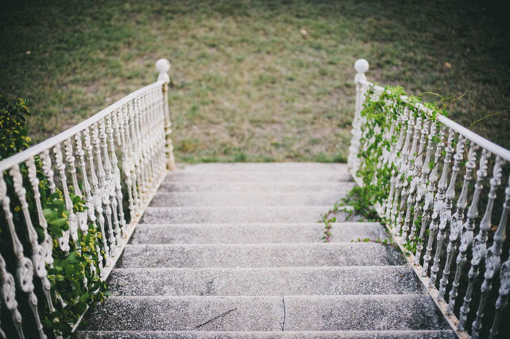 Stone stairs with ornate white railings, overgrown with greenery, leading upwards. - Barcelona Wedding Photographer