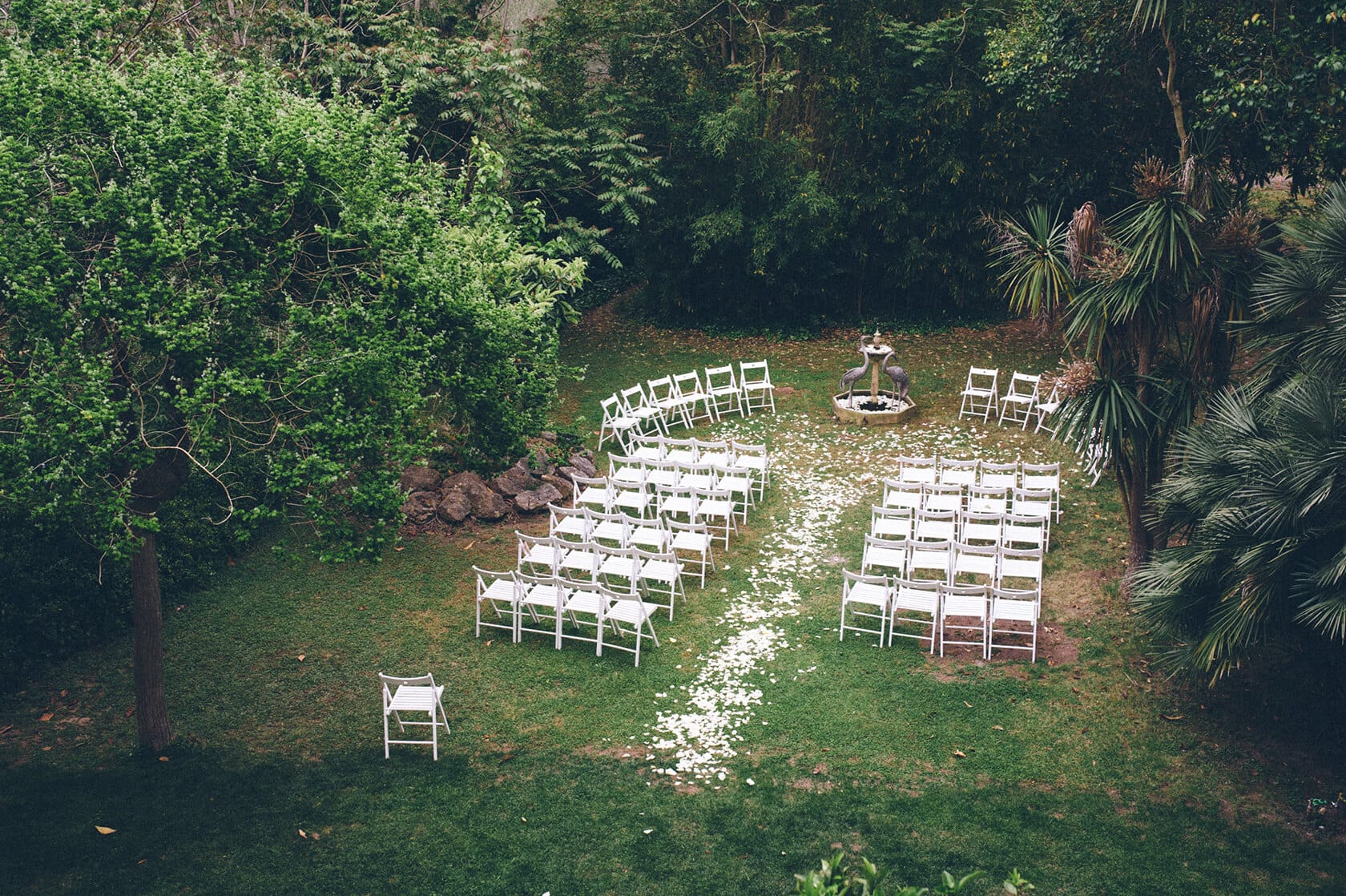 Wedding ceremony setup at Villa Almanita, Sitges: white chairs arranged on grass. - Barcelona Wedding Photographer