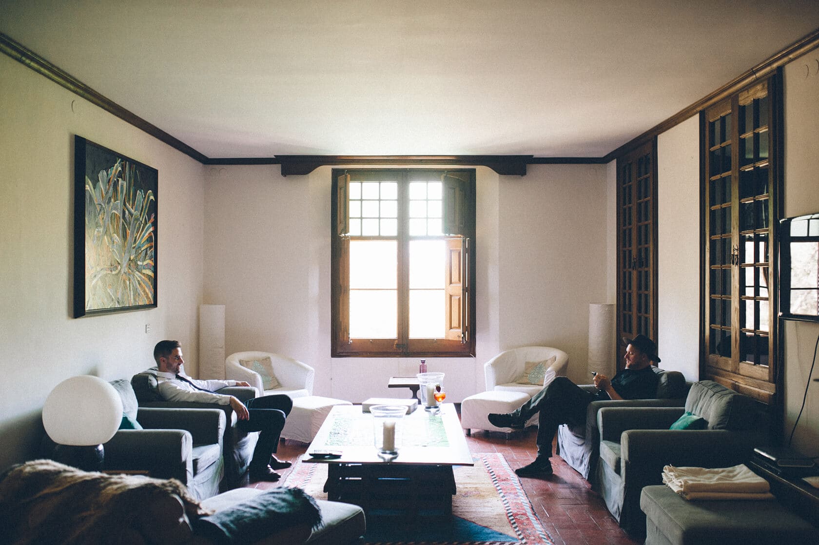 Groomsmen relaxing in a villa living room at destination wedding villa Almanita Sitges. - Barcelona Wedding Photographer