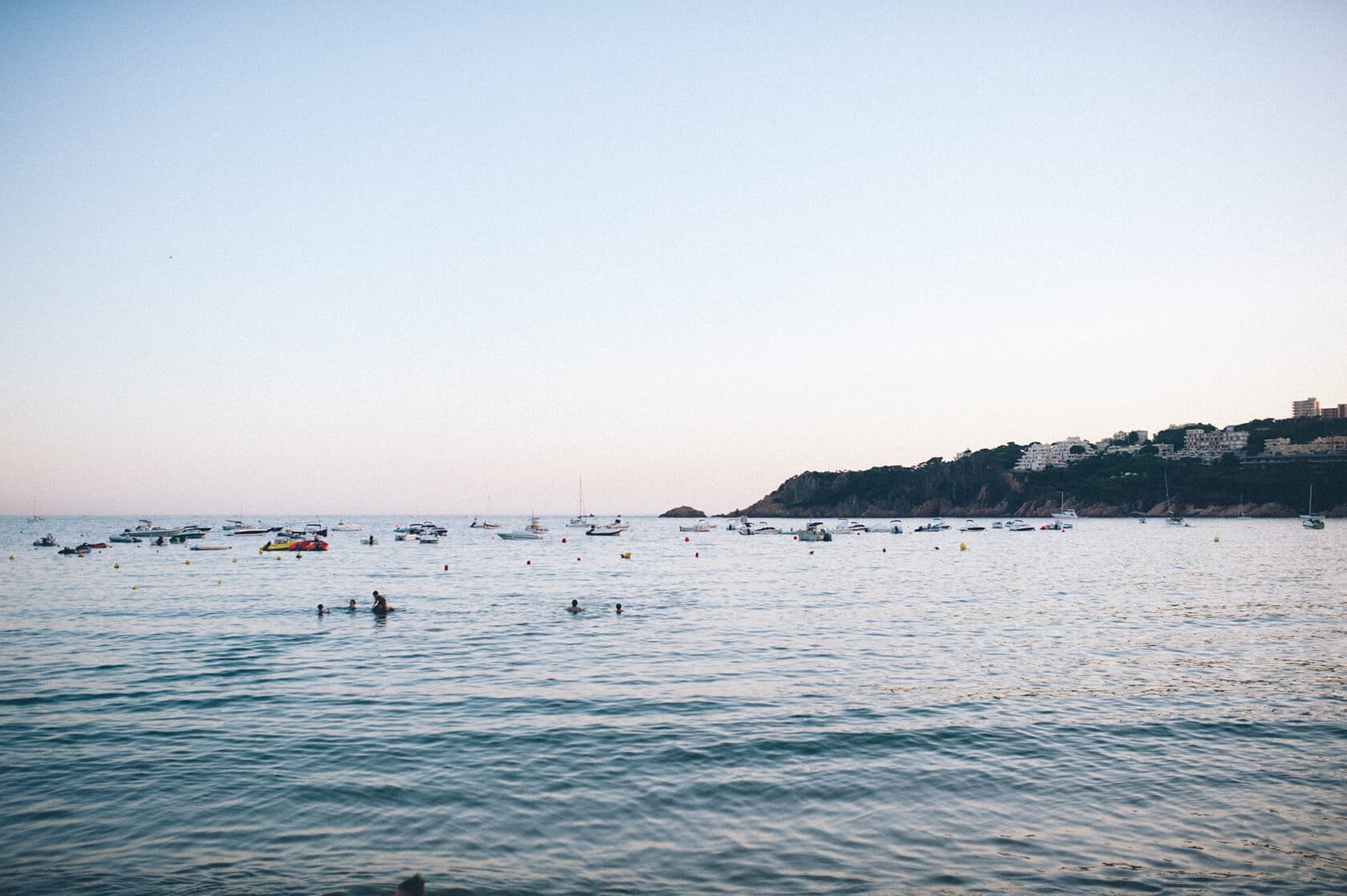 Boats anchored in a bay near a coastal town, S'Agaro, Spain. - Barcelona Wedding Photographer