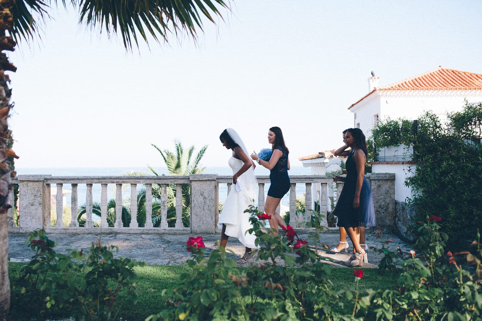 Bride and bridesmaids walk by the sea in S'Agaro, Spain. - Barcelona Wedding Photographer