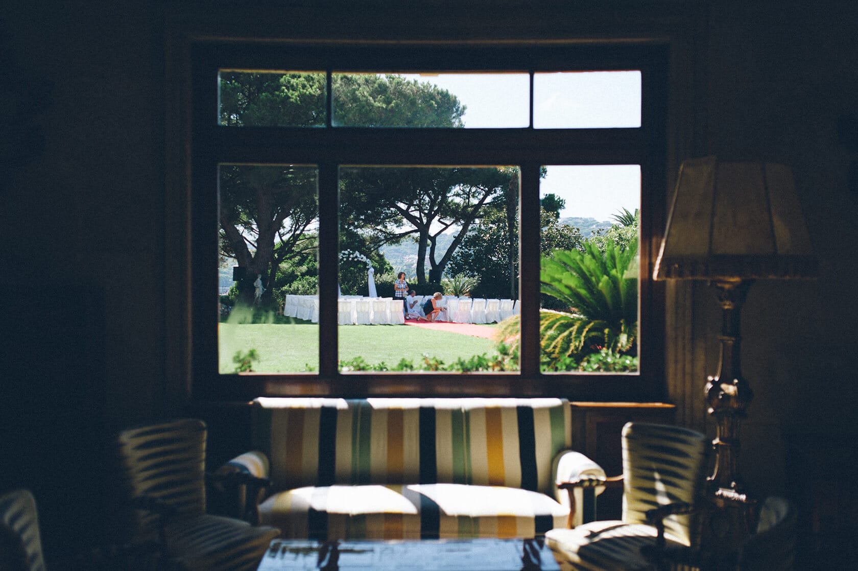 Tsega & Anders wedding ceremony setup in S'Agaro, Spain, viewed through a window. - Barcelona Wedding Photographer