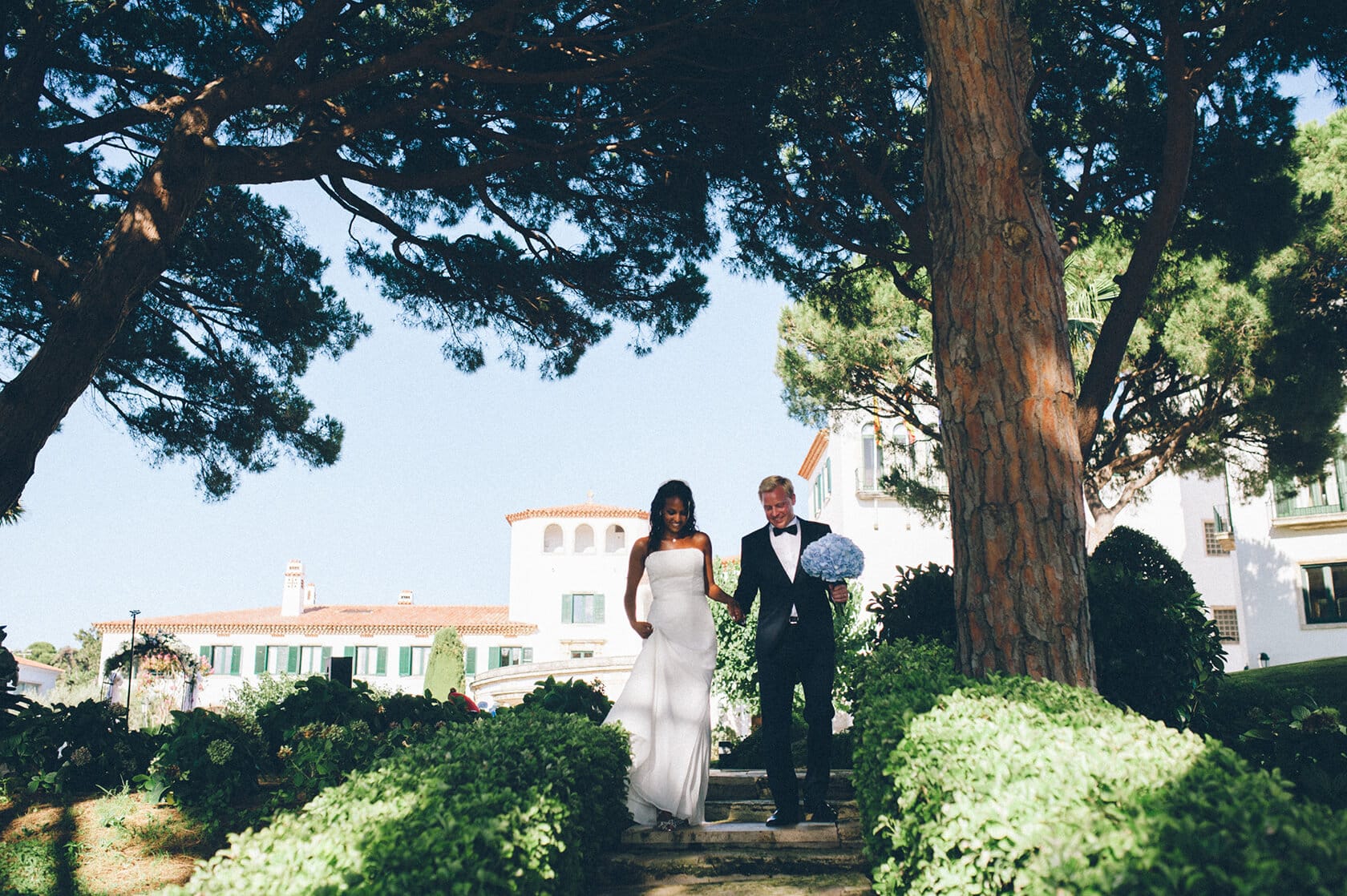 Bride and groom walk down steps in S'Agaro, Spain, wedding photographer. - Barcelona Wedding Photographer