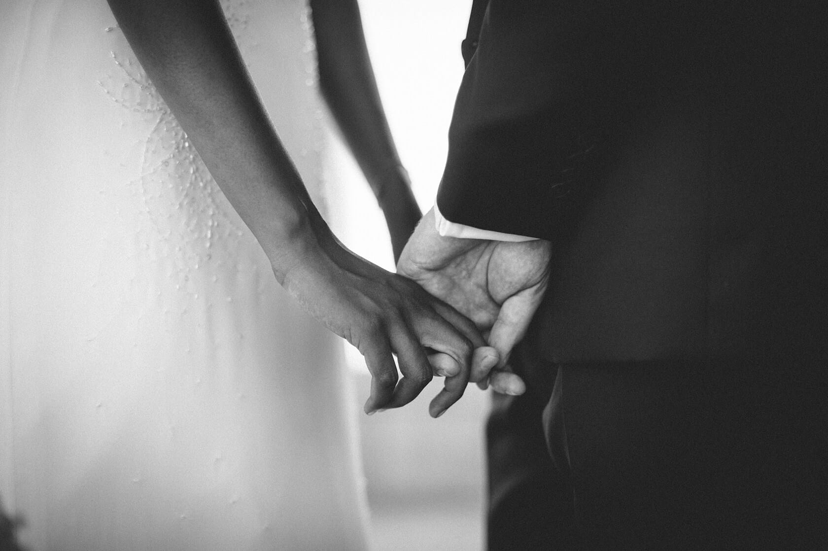 Close-up of a bride and groom's hands clasped during their wedding ceremony in S'Agaro, Spain. - Barcelona Wedding Photographer