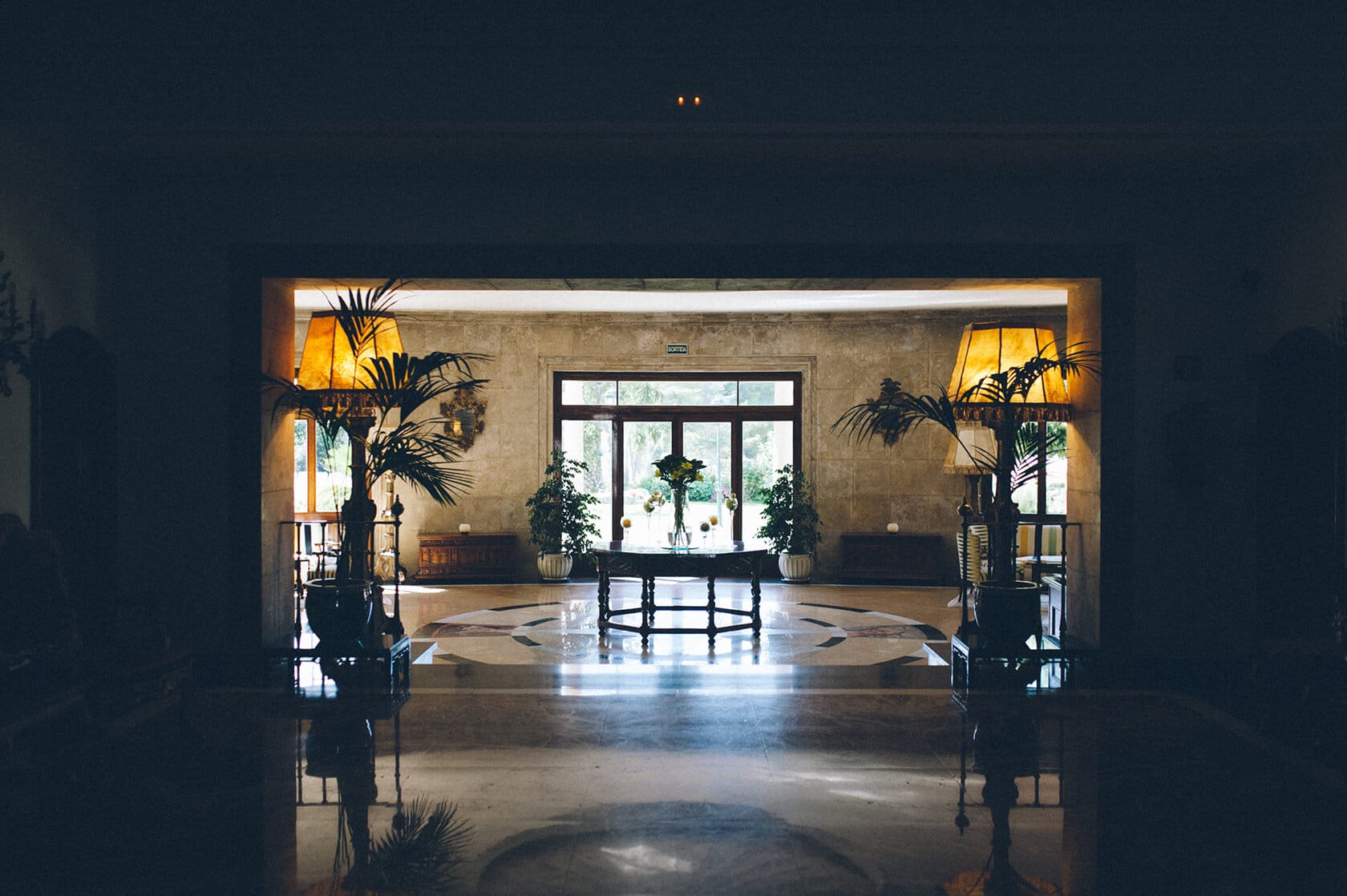 Elegant hotel lobby in S'Agaro, Spain, with palm trees and ornate table - Barcelona Wedding Photographer