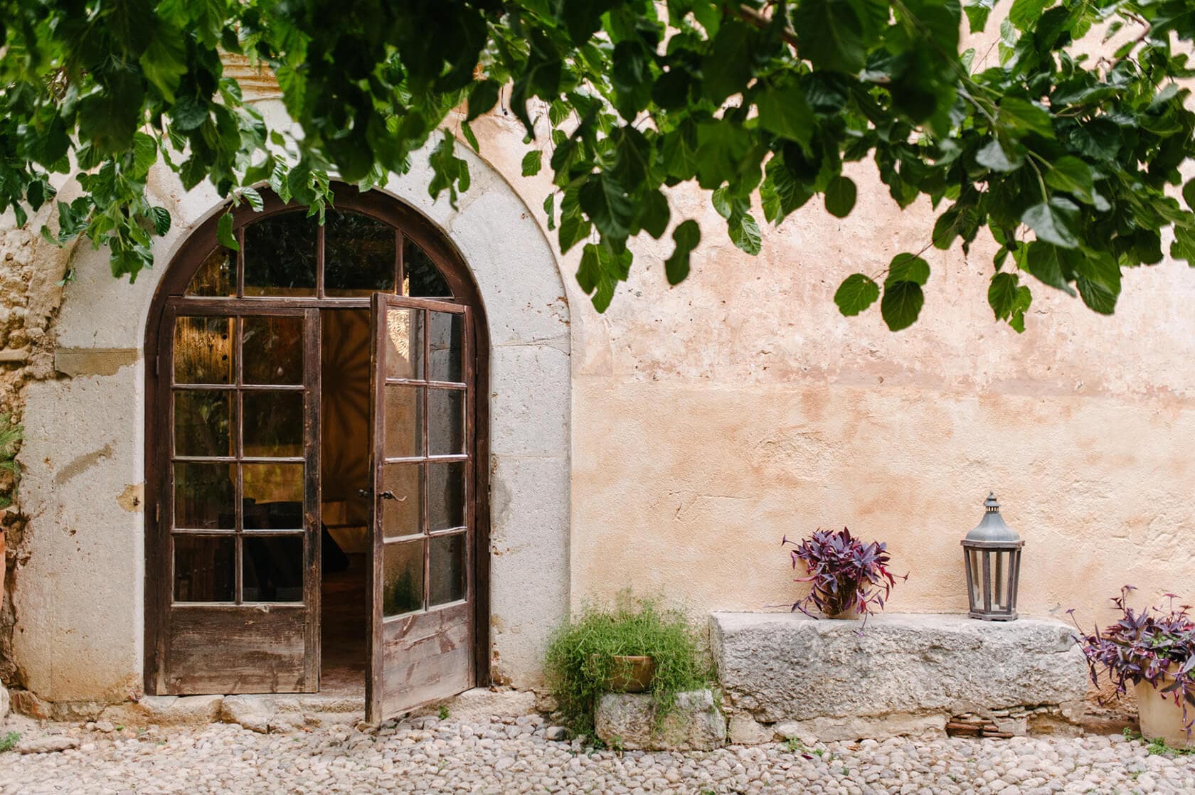 Rustic arched doorway of a wedding villa in Sitges with vines and a lantern - Barcelona Wedding Photographer