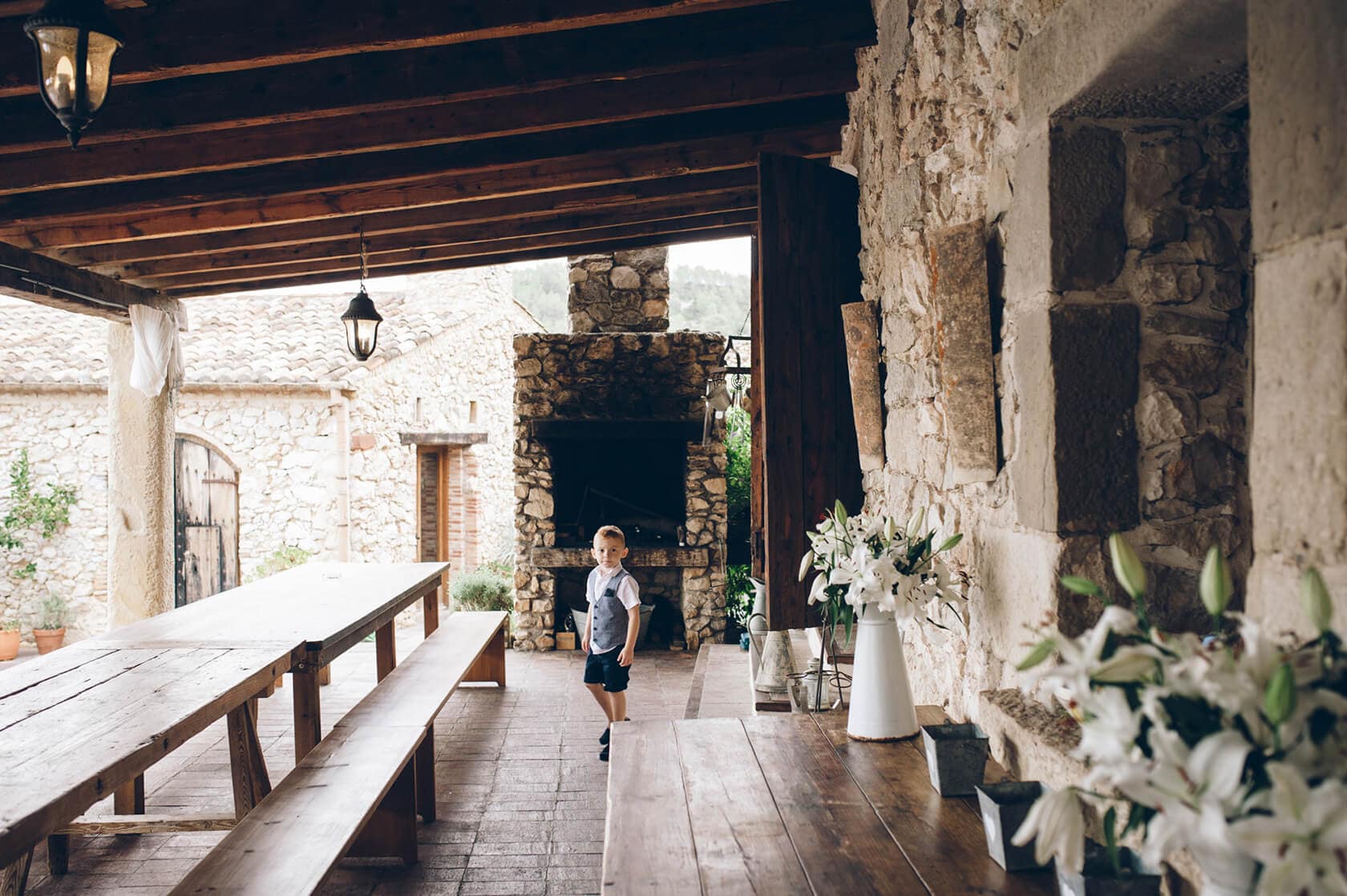 Boy in vest and shorts at outdoor wedding reception venue in Sitges - Barcelona Wedding Photographer