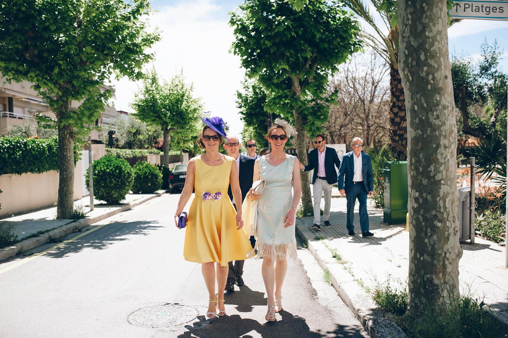 Wedding guests walk down a tree-lined street at Casanova Estate wedding venue. - Barcelona Wedding Photographer