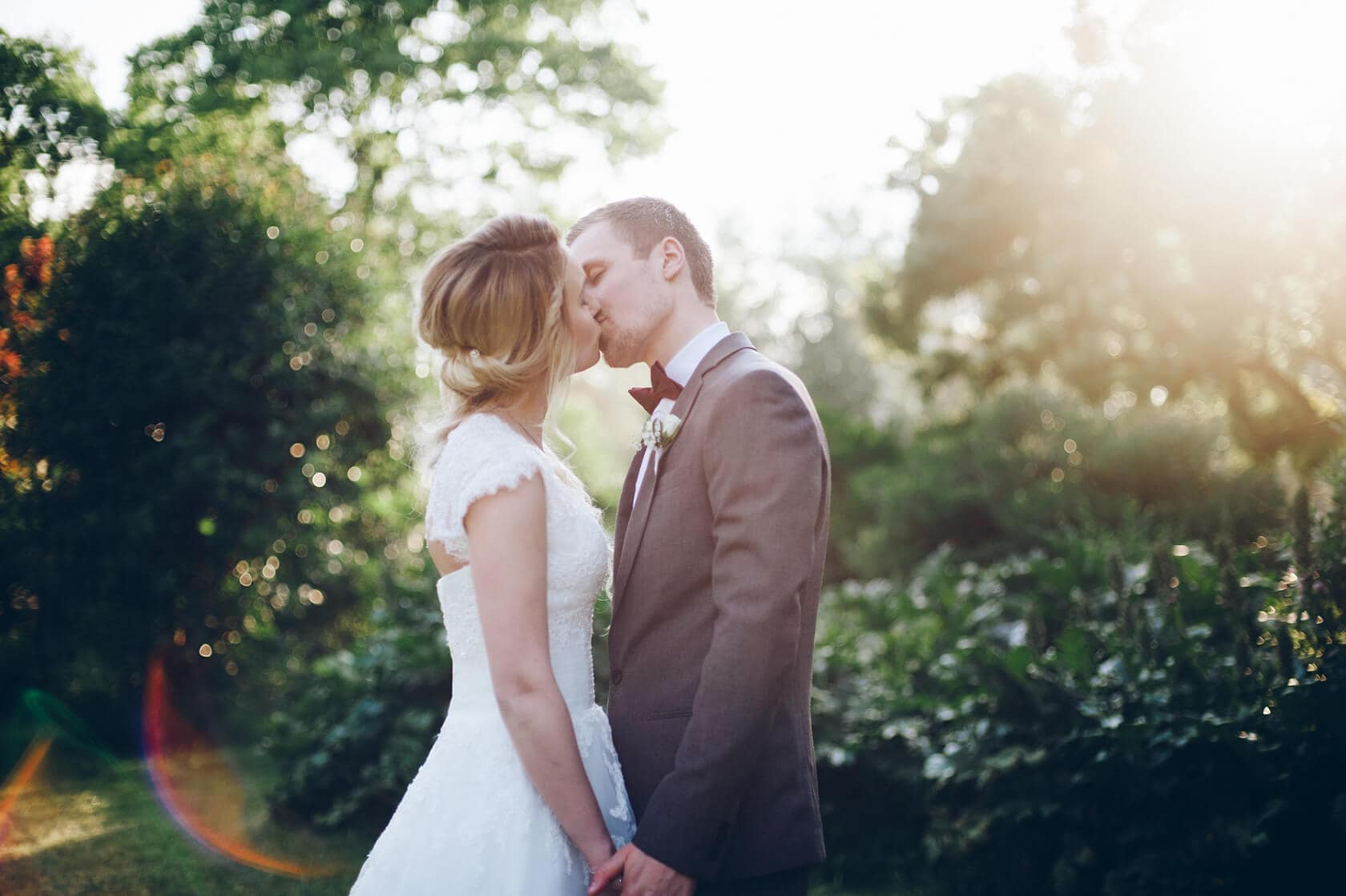 Bride and groom kissing in a sunlit garden, Barcelona wedding photographer - Barcelona Wedding Photographer