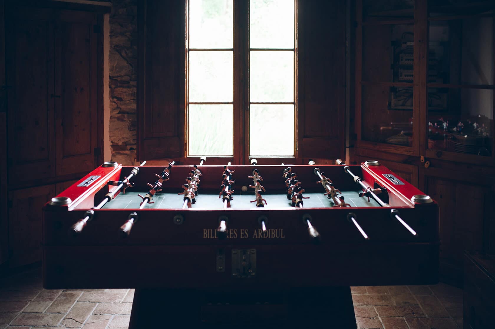 Foosball table in a room with a large window, possibly at a gay wedding in Sitges. - Barcelona Wedding Photographer