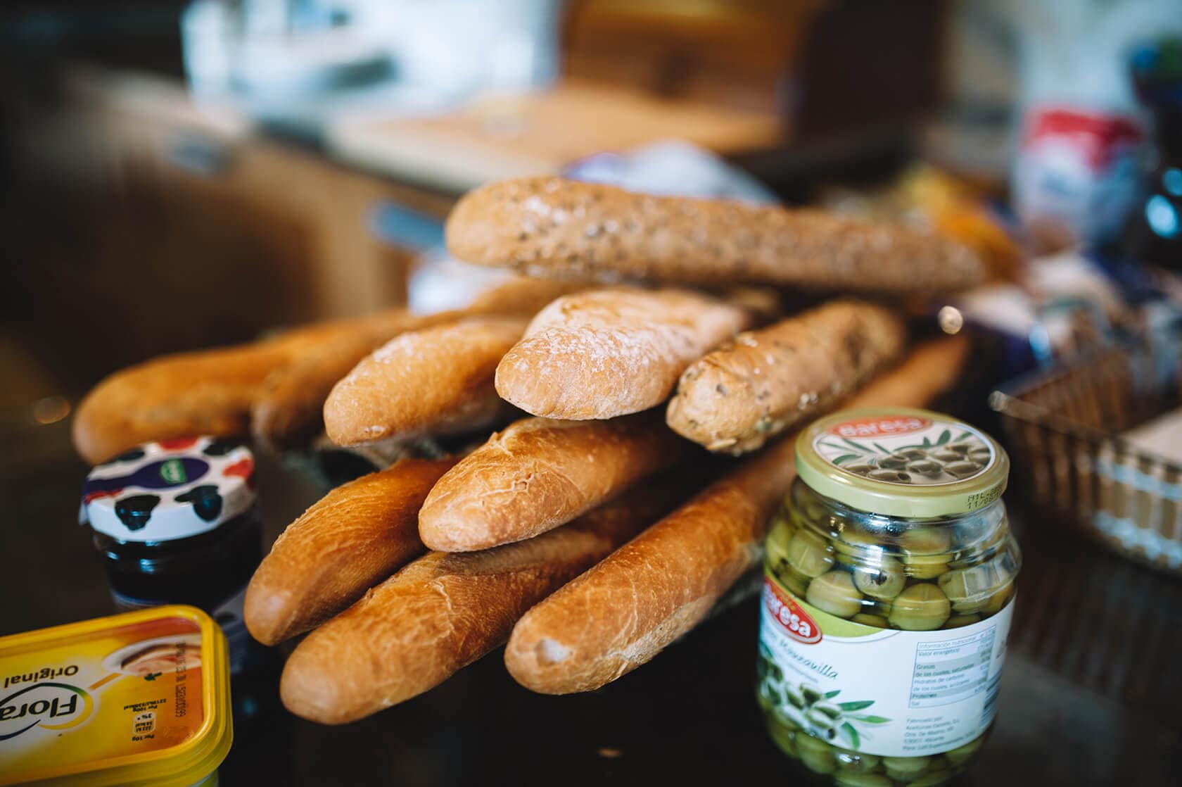 Baguettes, olives, and butter on a table, perfect for a wedding villa in Sitges. - Barcelona Wedding Photographer