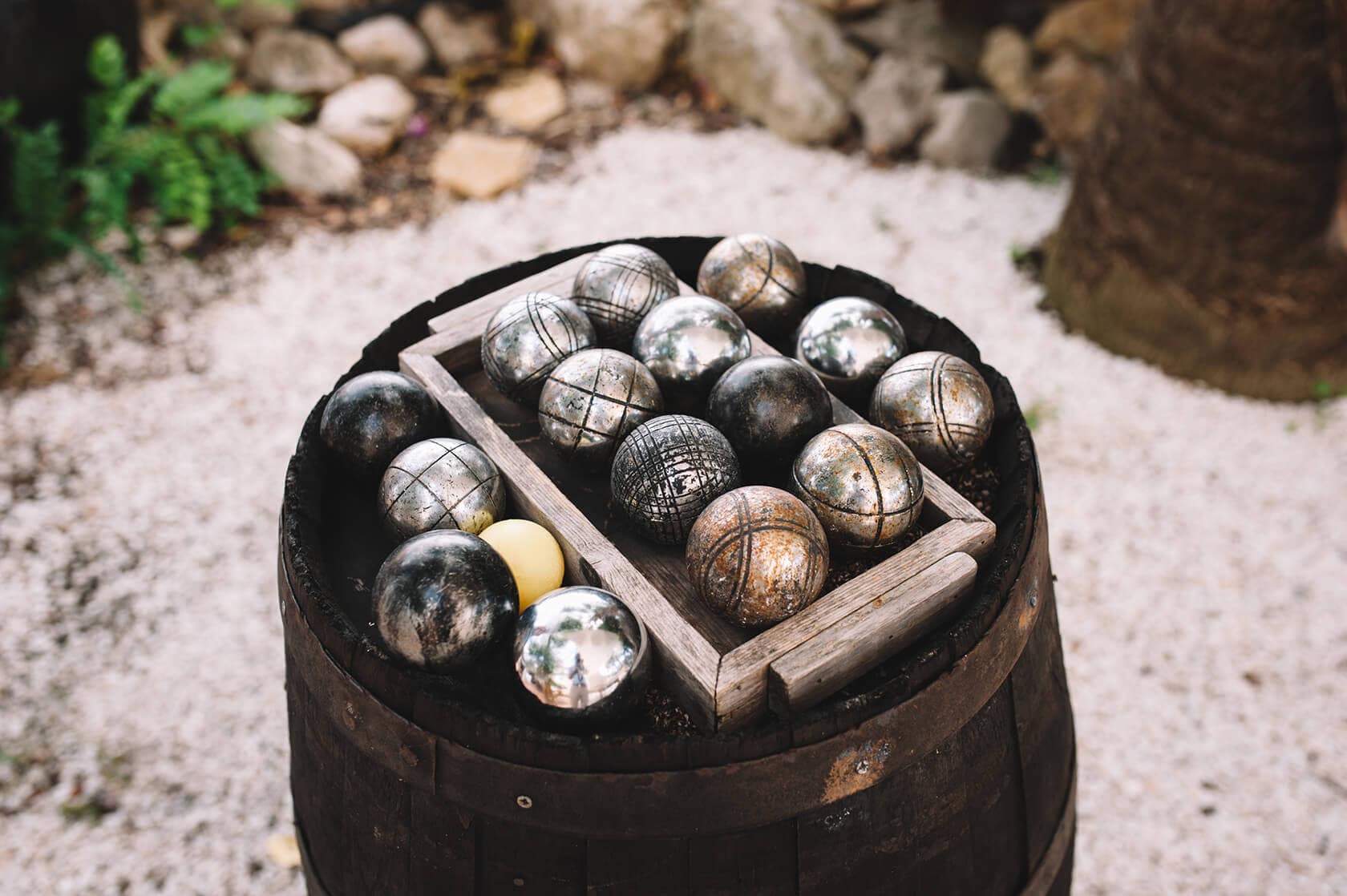 Pétanque balls on a barrel, ideal for outdoor games at wedding villas in Sitges. - Barcelona Wedding Photographer