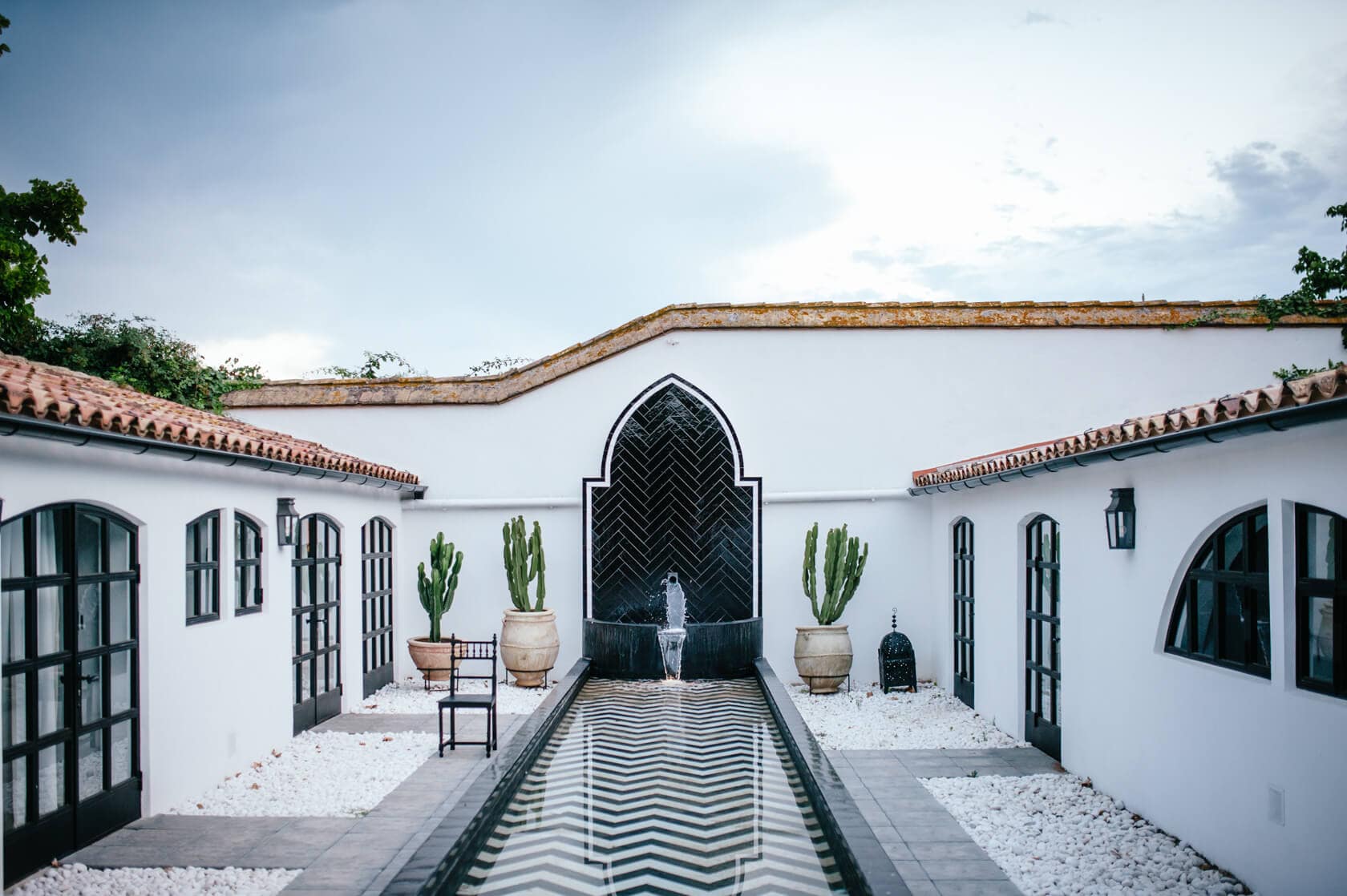 Courtyard of a wedding villa in Sitges with a water feature and cacti. - Barcelona Wedding Photographer