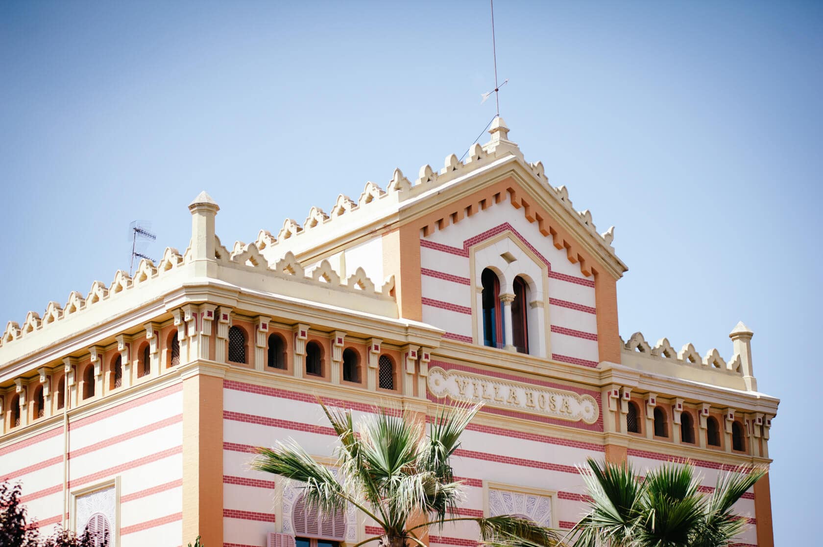 Villa Rosa, a charming wedding villa in Sitges, with palm trees in foreground - Barcelona Wedding Photographer
