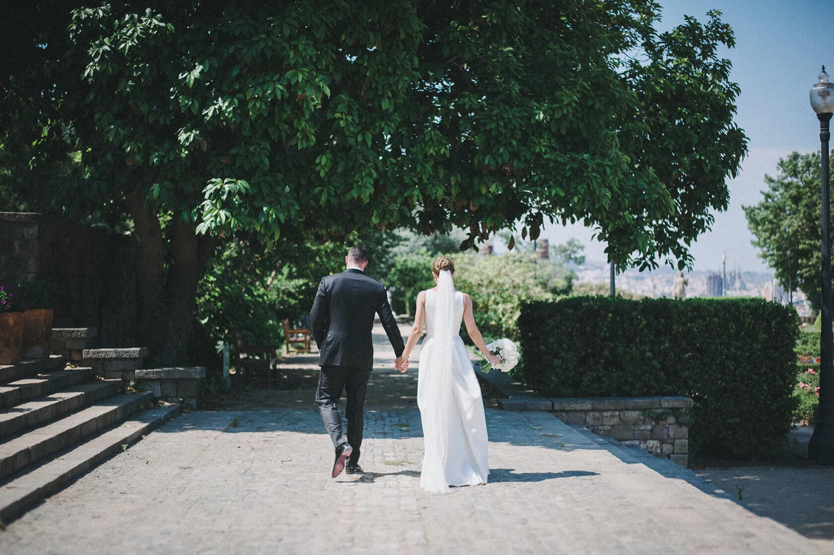 Bride and groom walking hand-in-hand at Hotel Miramar Barcelona wedding. - Barcelona Wedding Photographer