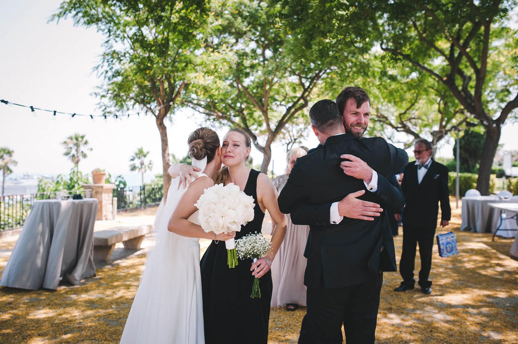 Hotel Miramar Barcelona wedding: Bride hugs guests outdoors. - Barcelona Wedding Photographer