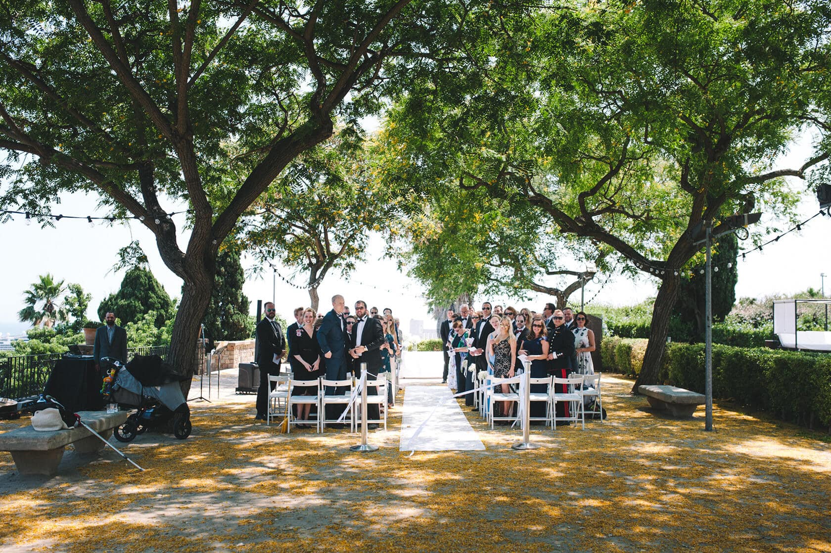 Outdoor wedding ceremony at Hotel Miramar Barcelona with guests under trees. - Barcelona Wedding Photographer
