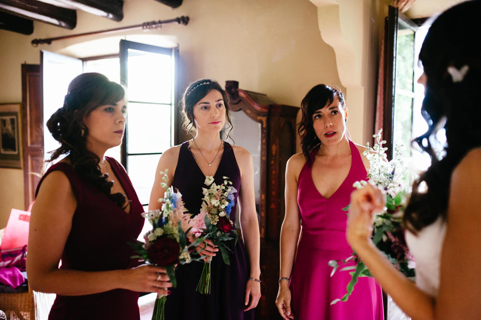Bridesmaids in jewel-toned dresses with bouquets at a wedding in Sitges - Barcelona Wedding Photographer