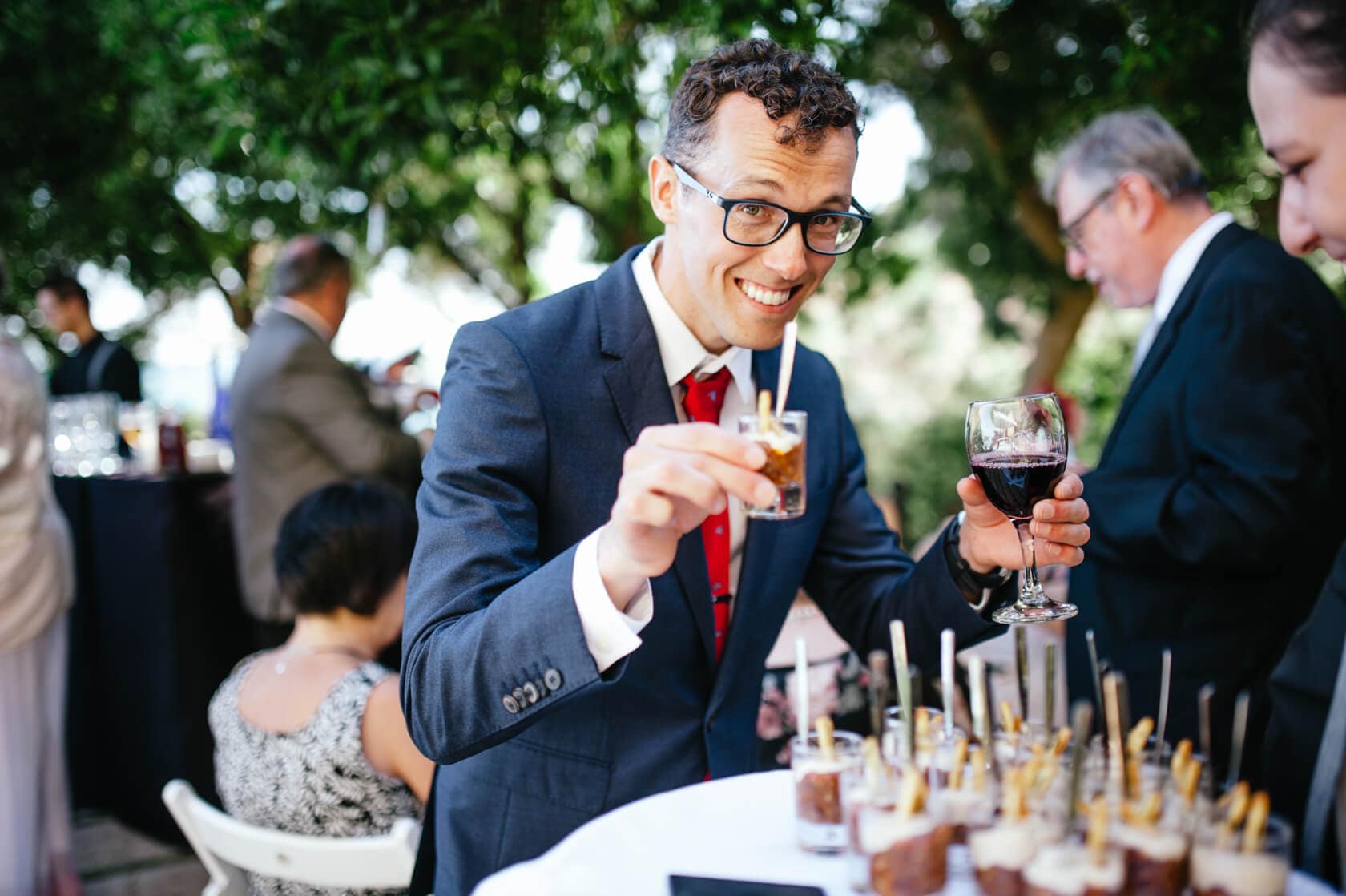 Man in suit holding drinks at a wedding in Sitges - Barcelona Wedding Photographer