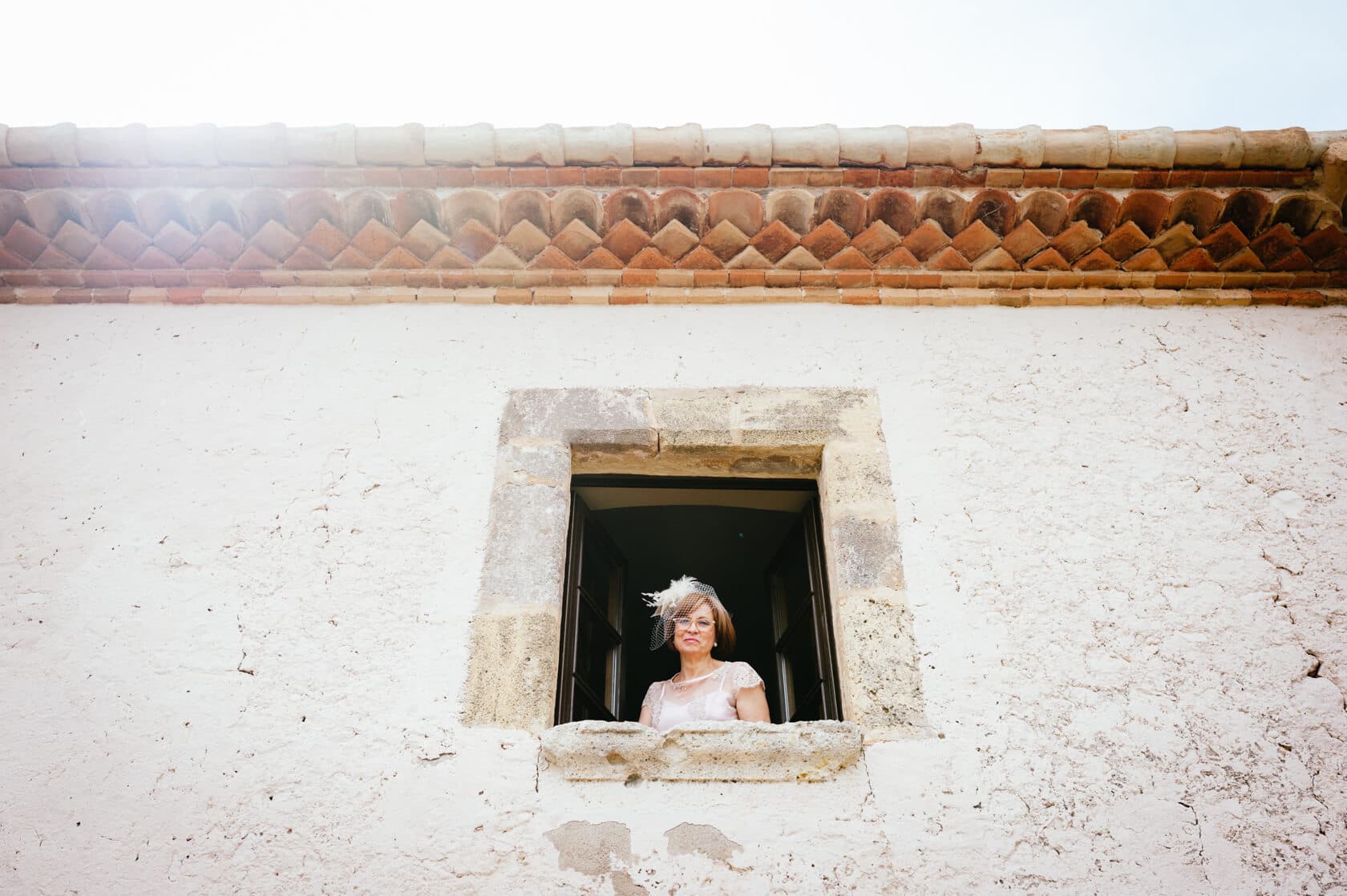 Mother of the bride in a window at a Castell de Tamarit wedding, Sitges - Barcelona Wedding Photographer