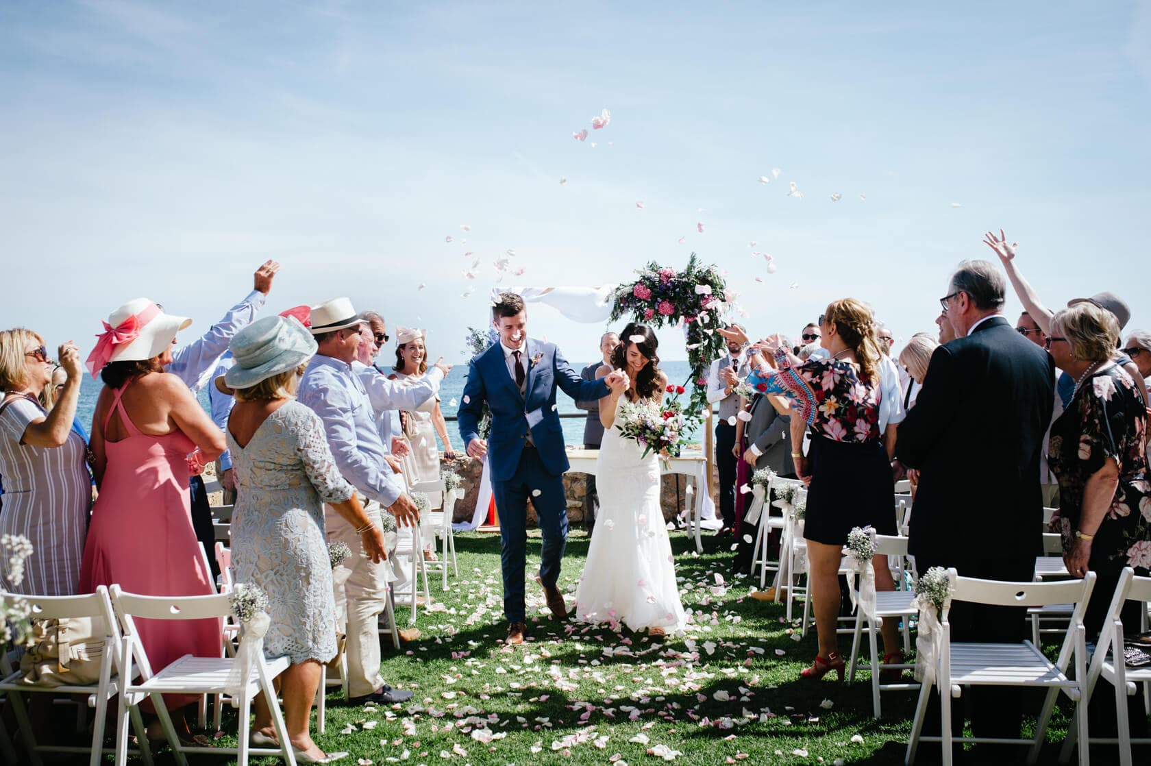 Marina & Peter's wedding at Castell de Tamarit, Sitges: couple exits under confetti. - Barcelona Wedding Photographer