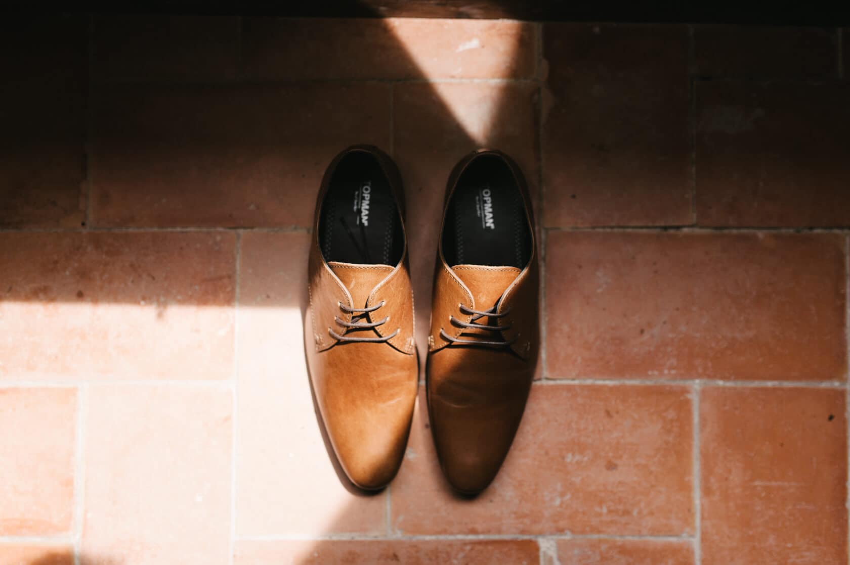 Brown leather dress shoes on terracotta tiles, Sitges wedding photography - Barcelona Wedding Photographer