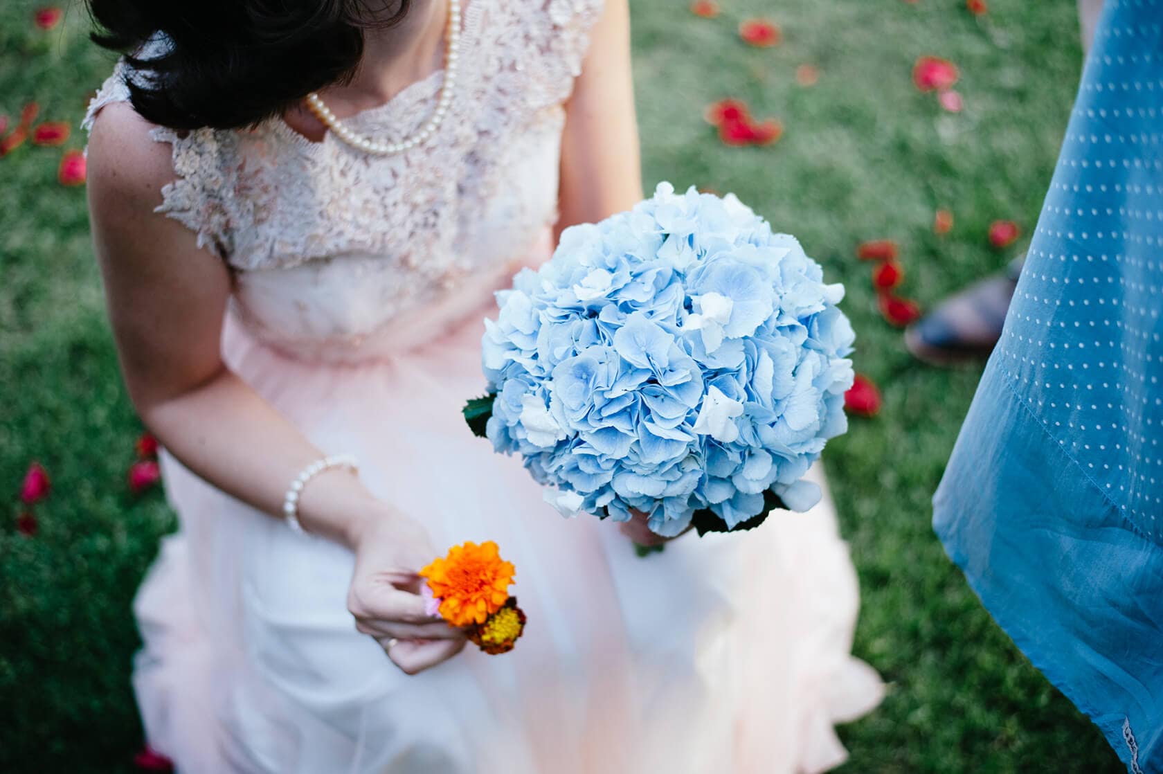 Bride in vintage style wedding dress holds blue hydrangea bouquet and orange flower - Barcelona Wedding Photographer