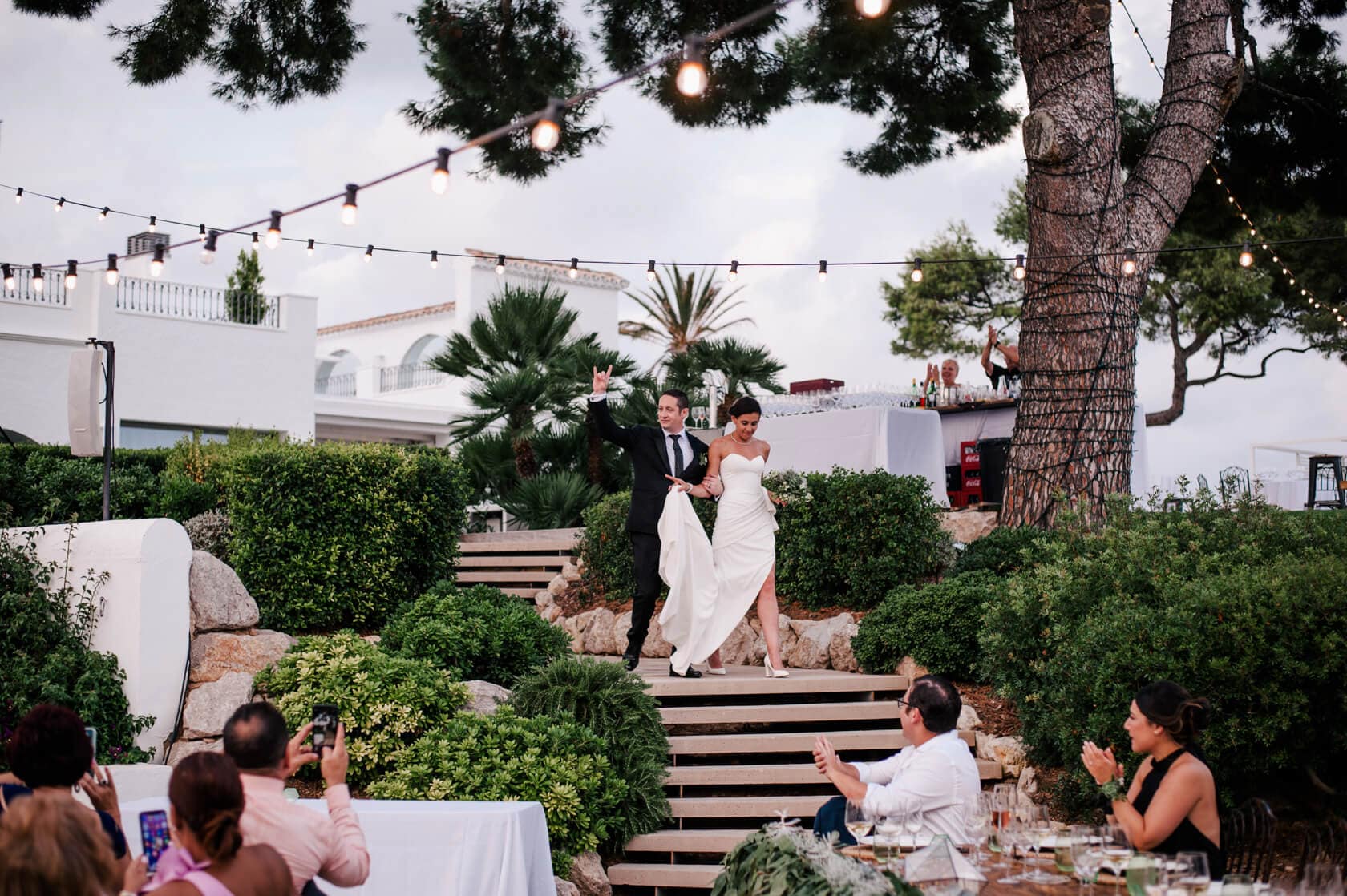 Hayley and Mark, a bride and groom, walk hand-in-hand at their wedding. - Barcelona Wedding Photographer