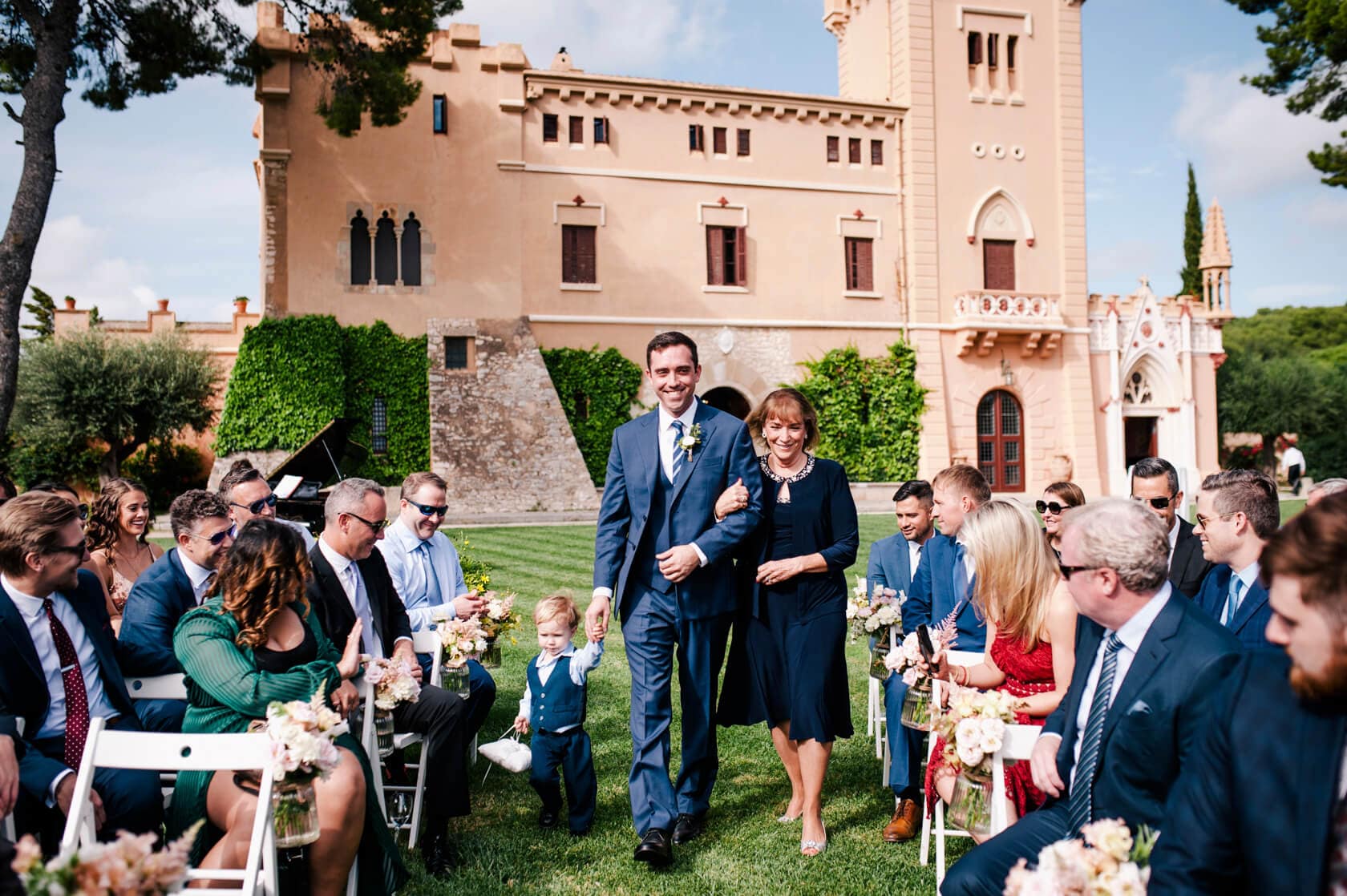 Hayley and Mark, a bride and groom, walk hand-in-hand at their wedding. - Barcelona Wedding Photographer