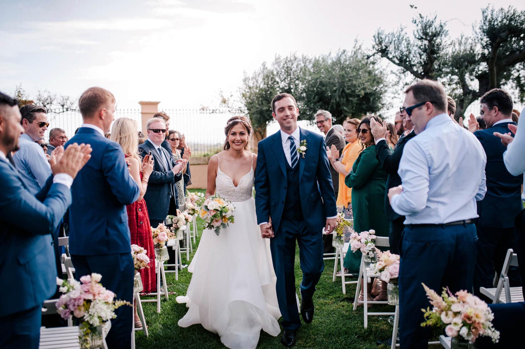 Hayley and Mark, a bride and groom, walk hand-in-hand at their wedding. - Barcelona Wedding Photographer