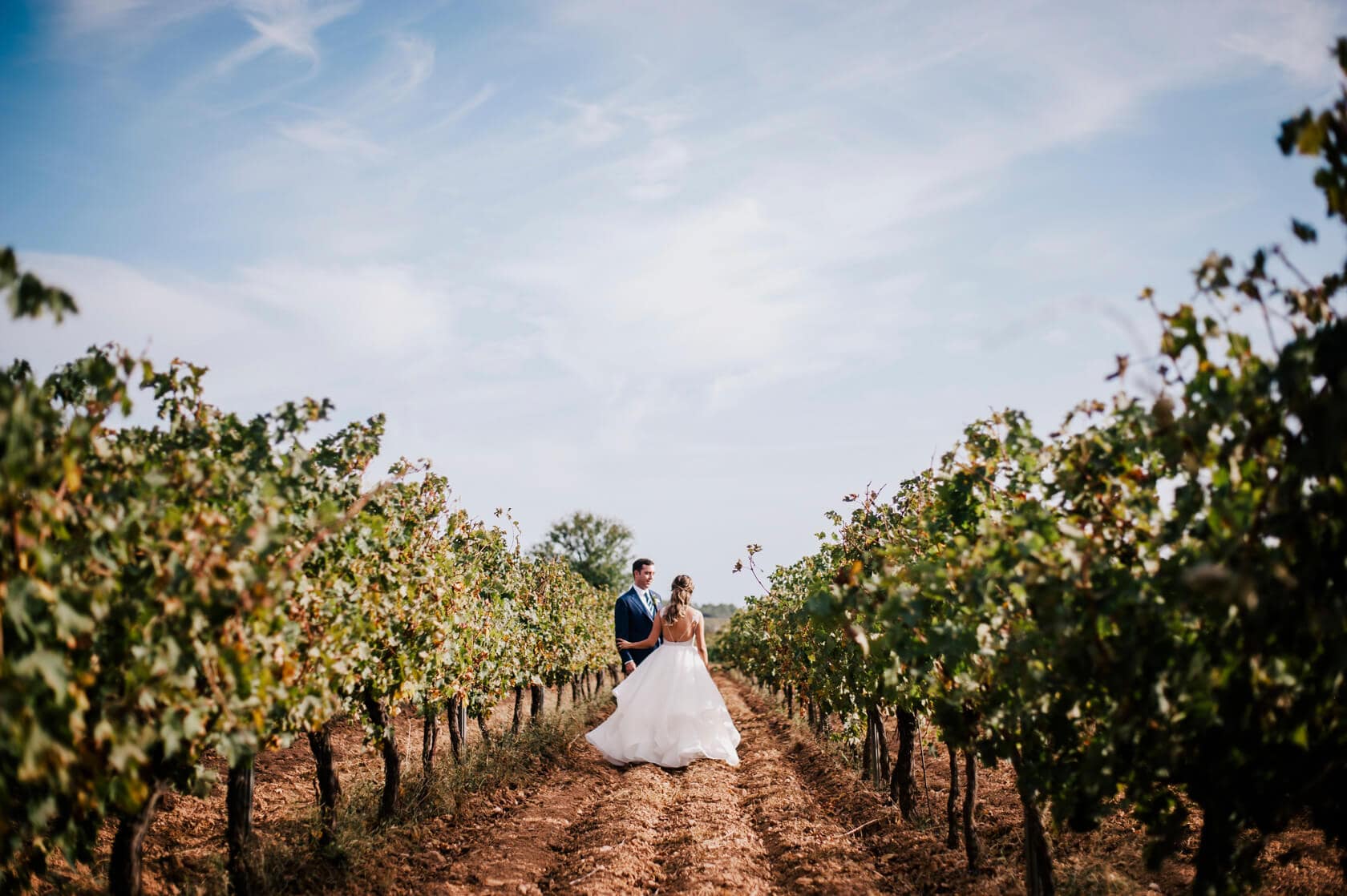 Hayley and Mark, a bride and groom, walk hand-in-hand at their wedding. - Barcelona Wedding Photographer