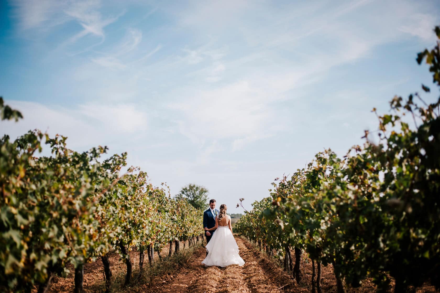 Hayley and Mark, a bride and groom, walk hand-in-hand at their wedding. - Barcelona Wedding Photographer