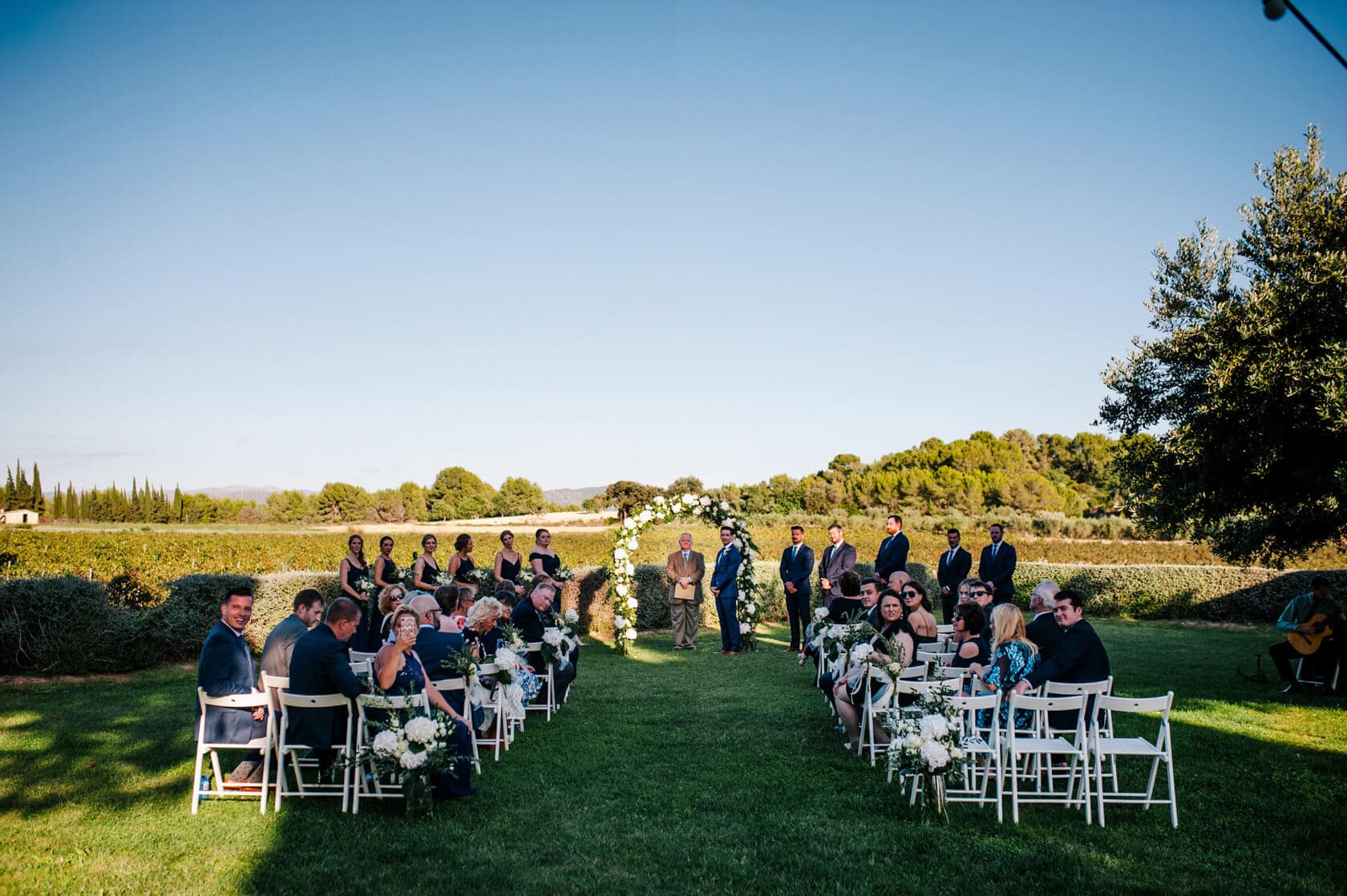 Hayley and Mark, a bride and groom, walk hand-in-hand at their wedding. - Barcelona Wedding Photographer