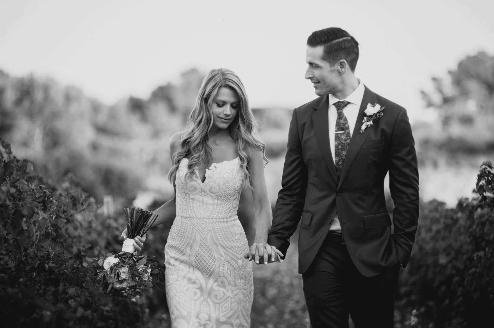 Hayley and Mark, a bride and groom, walk hand-in-hand at their wedding. - Barcelona Wedding Photographer