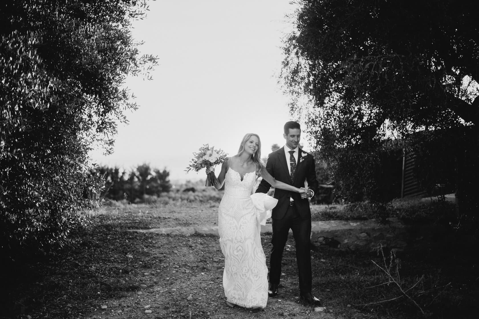 Melissa & Christopher walking at their Clos la Plana wedding in Sitges. - Barcelona Wedding Photographer