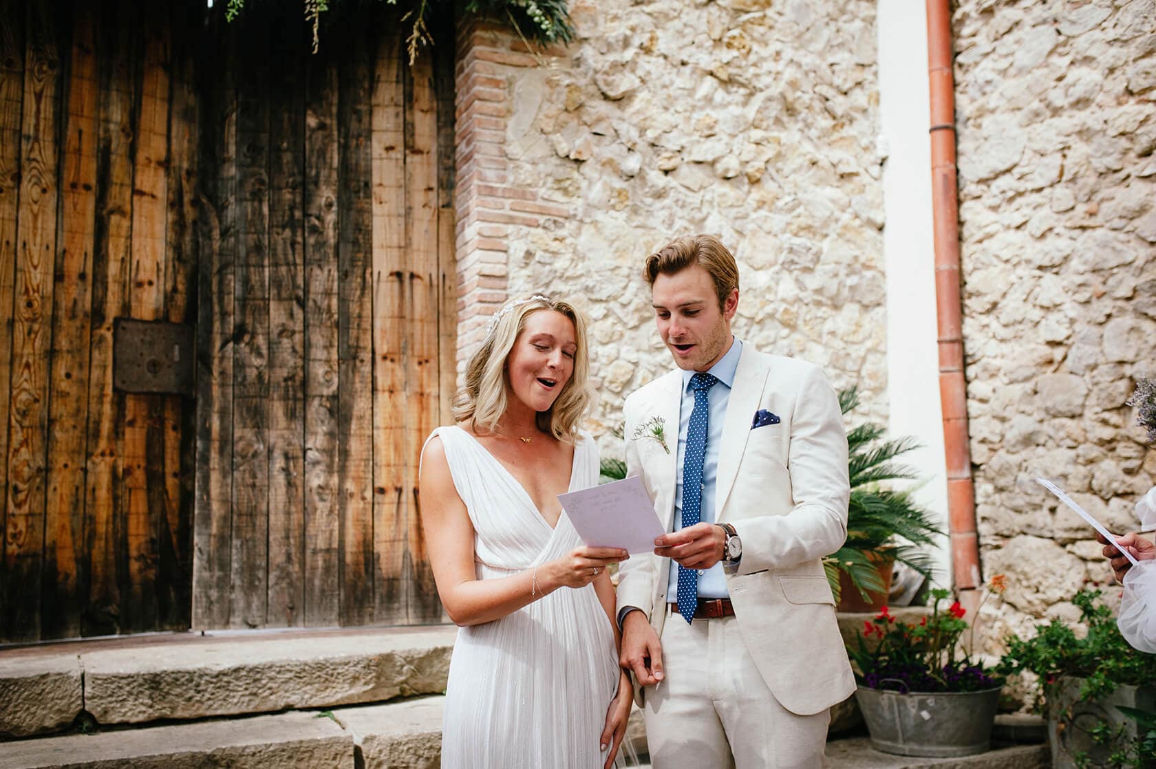 Newlywed couple in wedding attire on a sandy beach with ocean backdrop - Barcelona Wedding Photographer