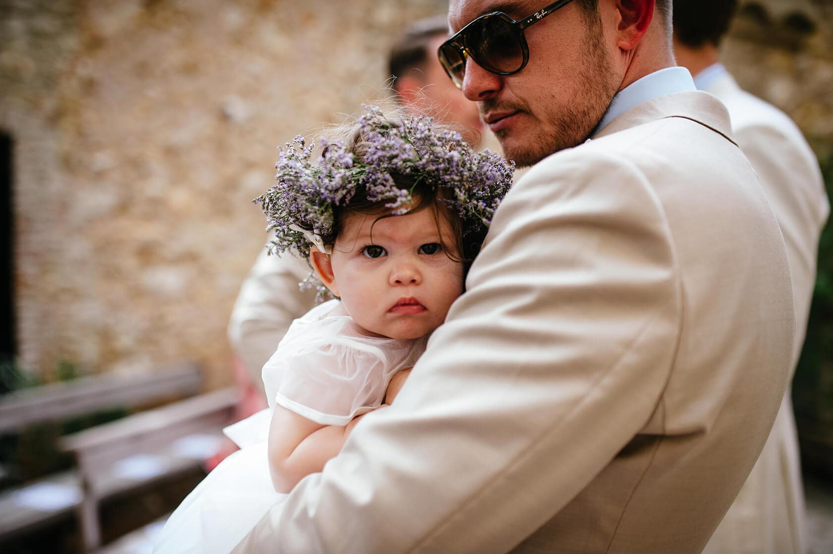 Best-man holding flower girl with floral crown at Casa Felix wedding venue. - Barcelona Wedding Photographer