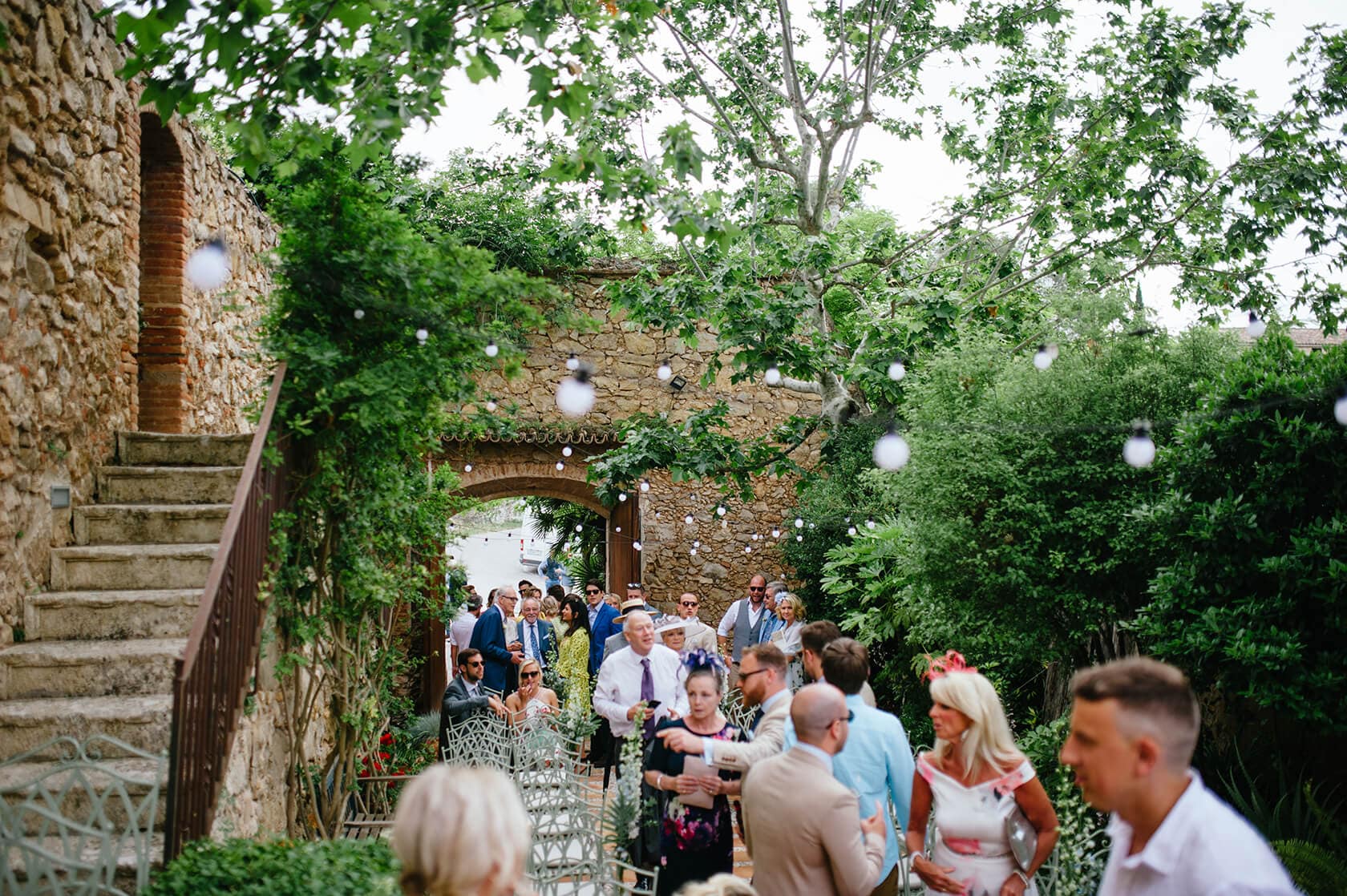 Hayley and Mark, a bride and groom, walk hand-in-hand at their wedding. - Barcelona Wedding Photographer